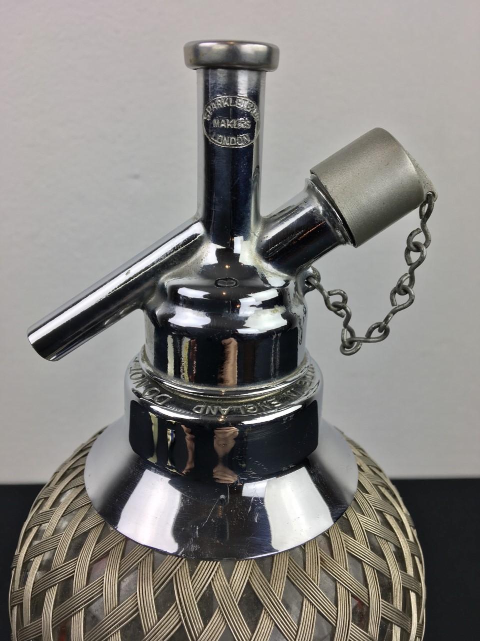 Antique soda Syphon by Sparklets London. This heavy glass syphon bottle is covered with wire mesh and has a rounded pedestal base. Sparklets Makers London. Do not fill above the red line - Made in England is marked on the chrome.
This Art Deco soda
