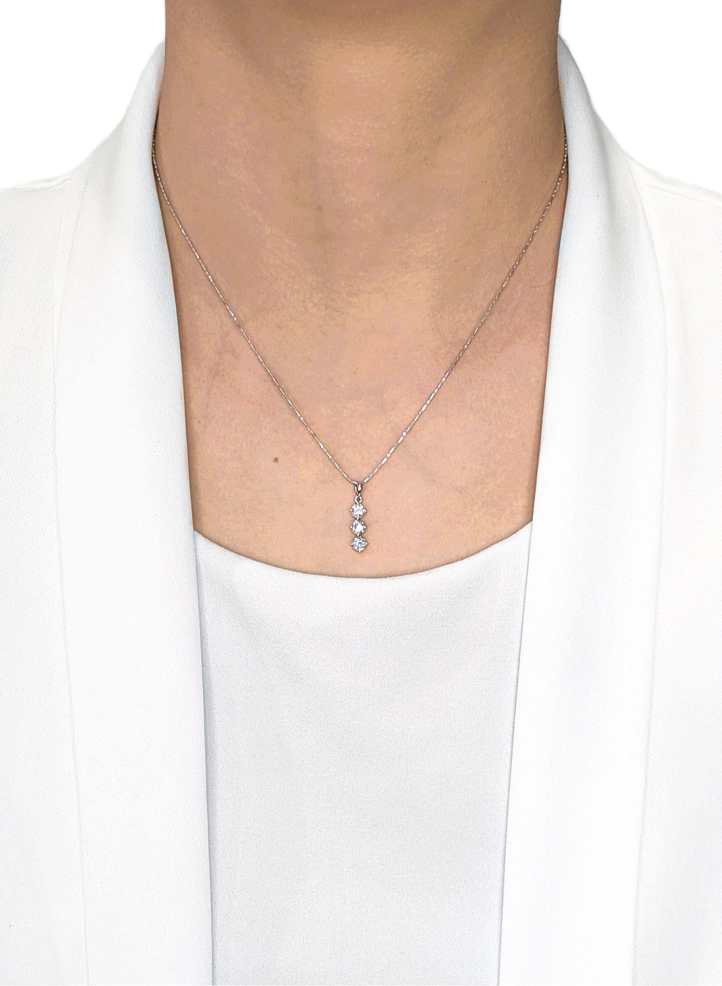 Minimalista con il massimo dello splendore, questo elegante pendente presenta tre diamanti naturali rotondi con taglio a brillante, per un totale di 0,72 carati, ognuno dei quali brilla di colore G e purezza VS. Sospese in una goccia verticale e