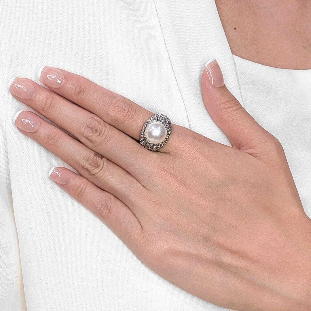 Questo affascinante anello presenta una luminosa perla bianca di 11,6 mm al centro, splendidamente contrastata dallo scintillio di 180 diamanti tondi brillanti naturali per un totale di 0,36 carati. Realizzata in oro bianco 18 carati, l'intricata