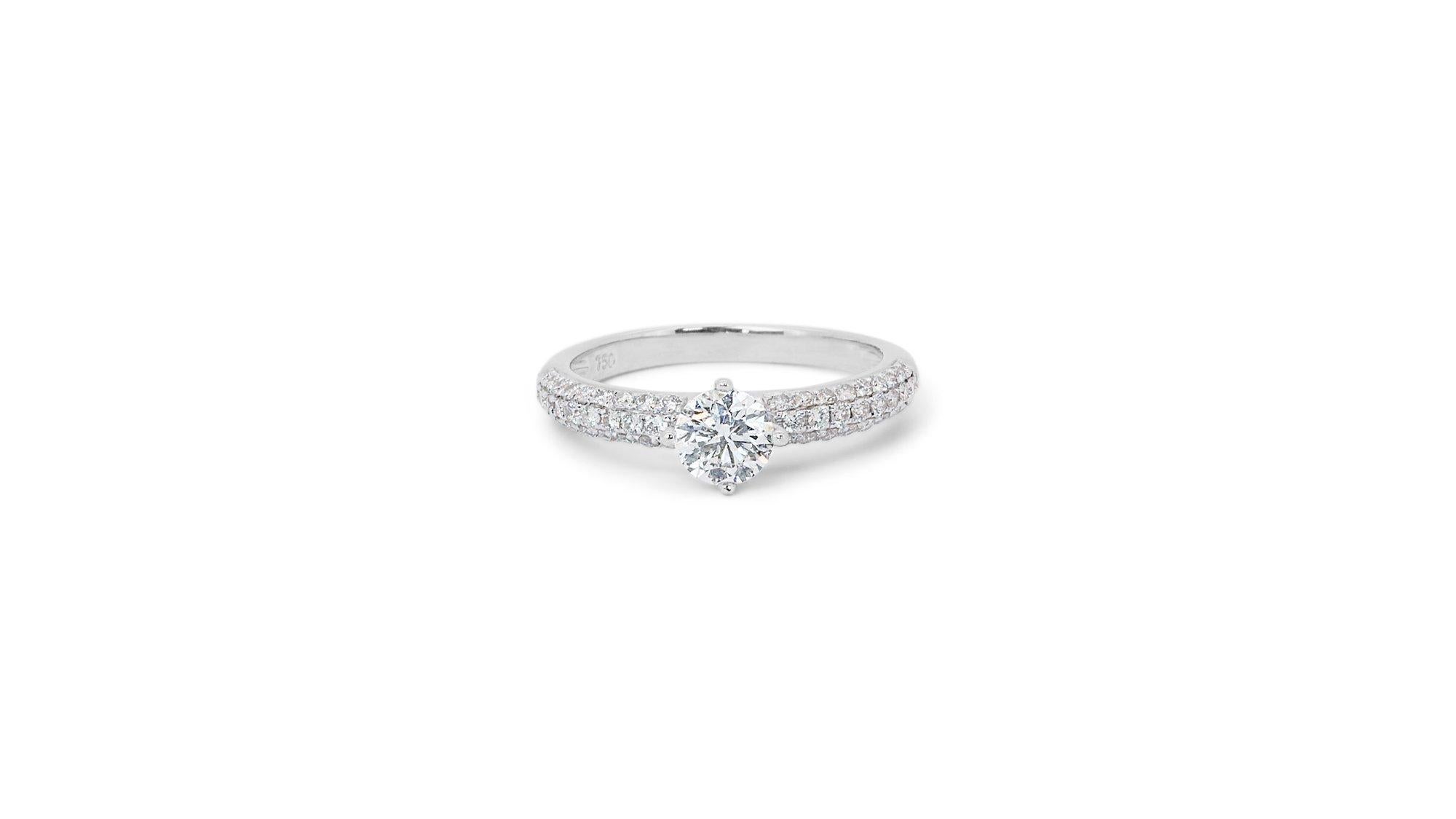 A fabulous Pave Ring with a dazzling 0.6-carat Round Brilliant natural diamond. It has 0.3 carats of side diamonds which add more to its elegance. The jewelry is made of 18K White Gold with a high-quality polish. It comes with an IGI certificate and