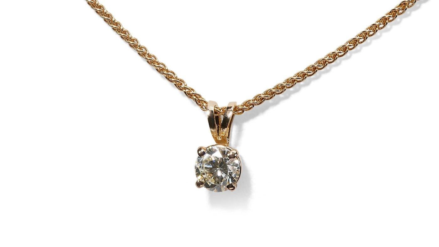 A ravishing solitaire necklace with a dazzling 1-carat round brilliant natural diamond in H VVS1. The jewelry is made of 18K Yellow Gold with a high-quality polish. The main stone is engraved with a laser inscription and has a GIA certificate and a