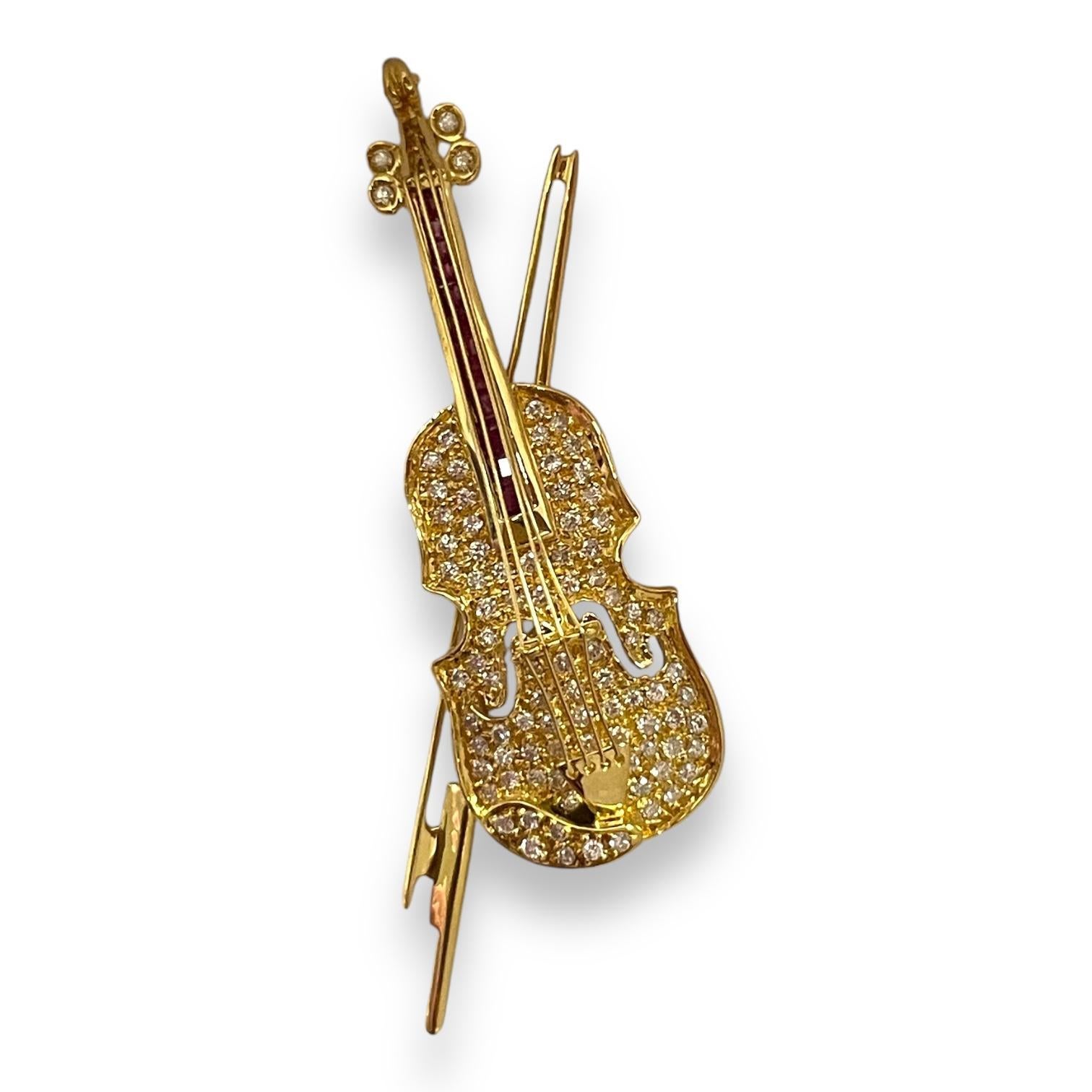 Discover the allure of music and luxury with this exquisite gold brooch, crafted in the shape of a violin. The body is adorned with sparkling crystals, capturing the essence of harmony and elegance. Each crystal is meticulously set to ensure a