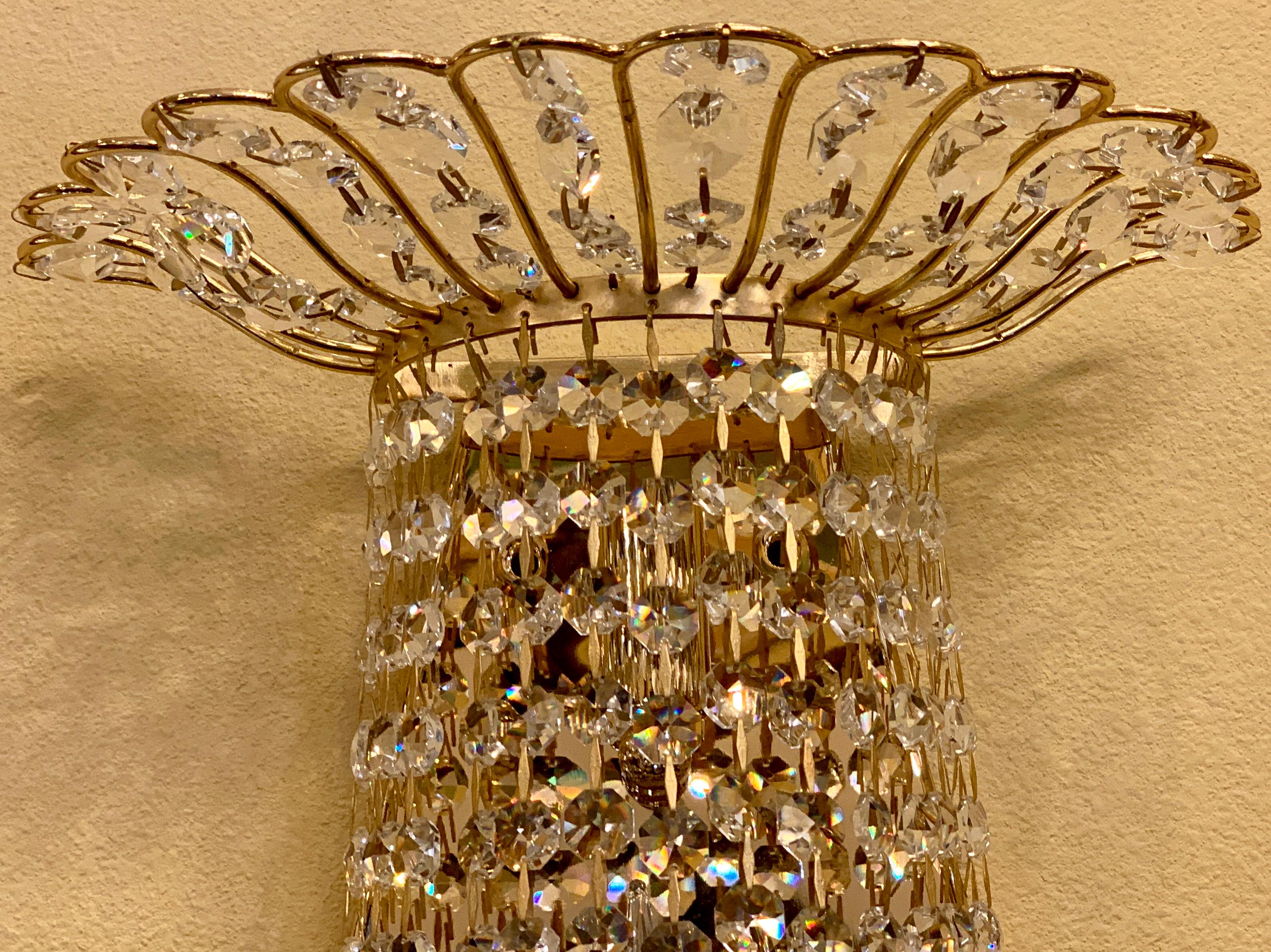 Large and elegantly shaped, rounded light sconce or wall chandelier has a shiny gold metal basket style frame with scalloped edges and is lavishly draped with sparkling, faceted, octagonal crystal beads for a dazzling effect. The bottom is finished