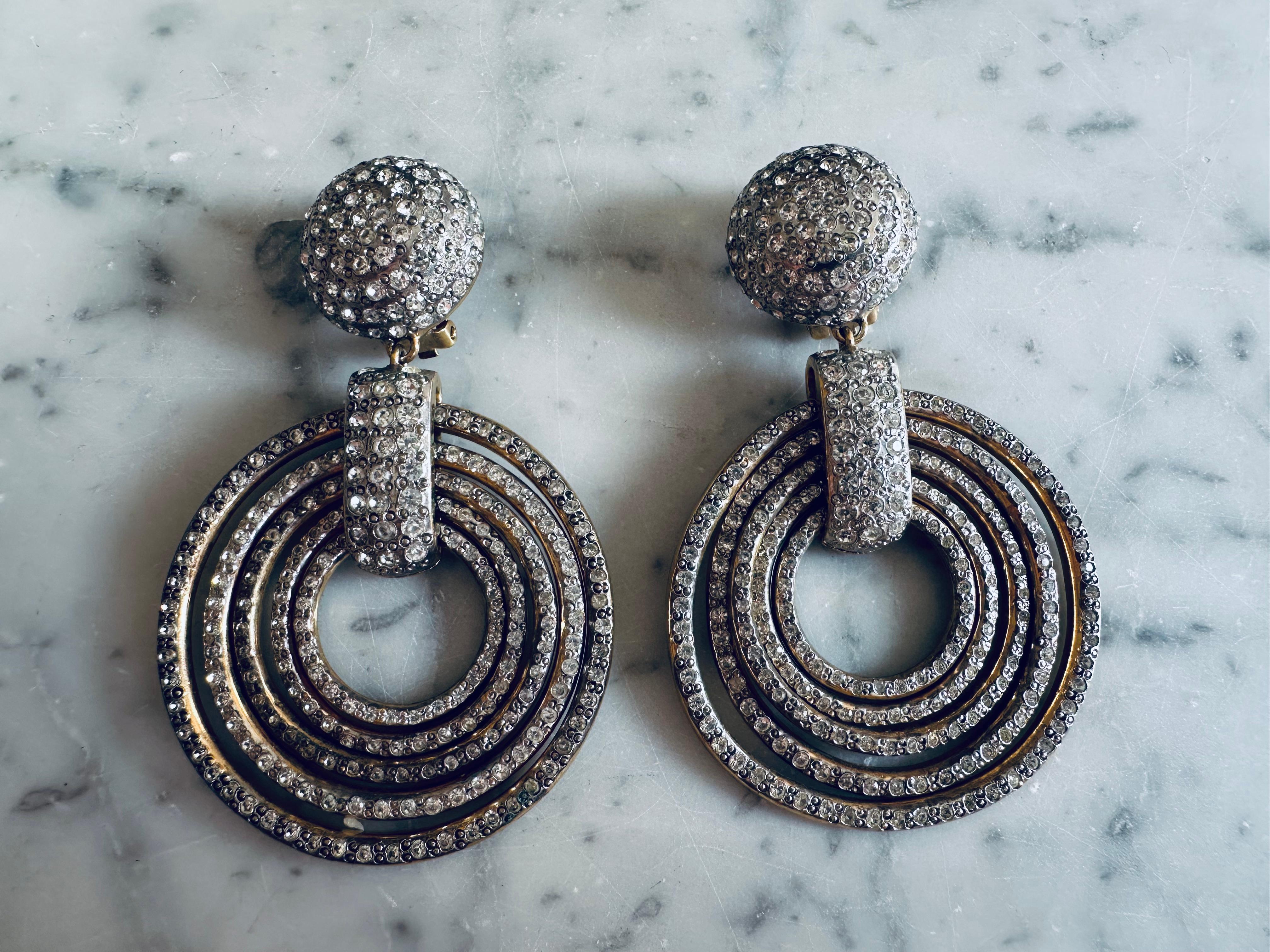 These glamorous clip-on earrings by Valentino are a dazzling example of 1980s fashion at its most opulent. Designed during a decade known for bold silhouettes, big hair, and unapologetic luxury, these vintage earrings capture the spirit of high-end