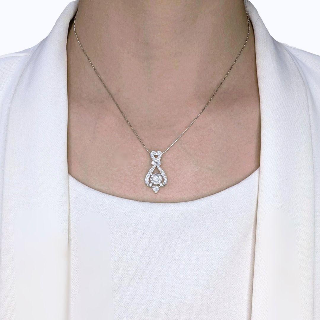 Imagínate este colgante descansando grácilmente en tu escote, un delicado susurro de luz y lujo. Es más que un simple accesorio; es un tema de conversación, una pieza que cuenta una historia. En su corazón, un brillante diamante redondo de 0,35 ct,