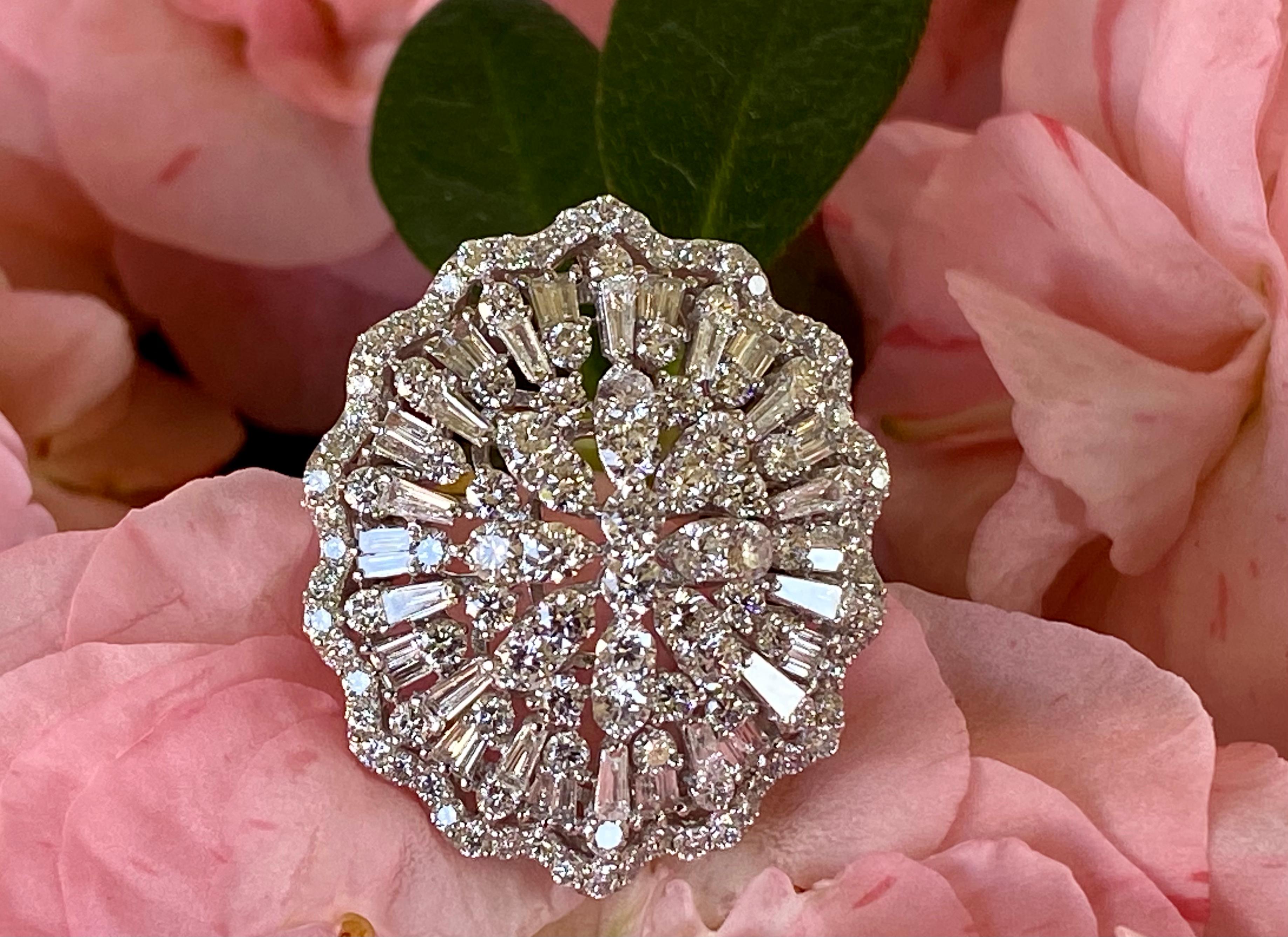 A magnificent estate approximately 9 carat diamond oval medallion shaped cocktail ring is set in 18 karat white gold and is comprised of approximately 180 round brilliant and baguette cut diamonds.  The medallion design features a domed center with