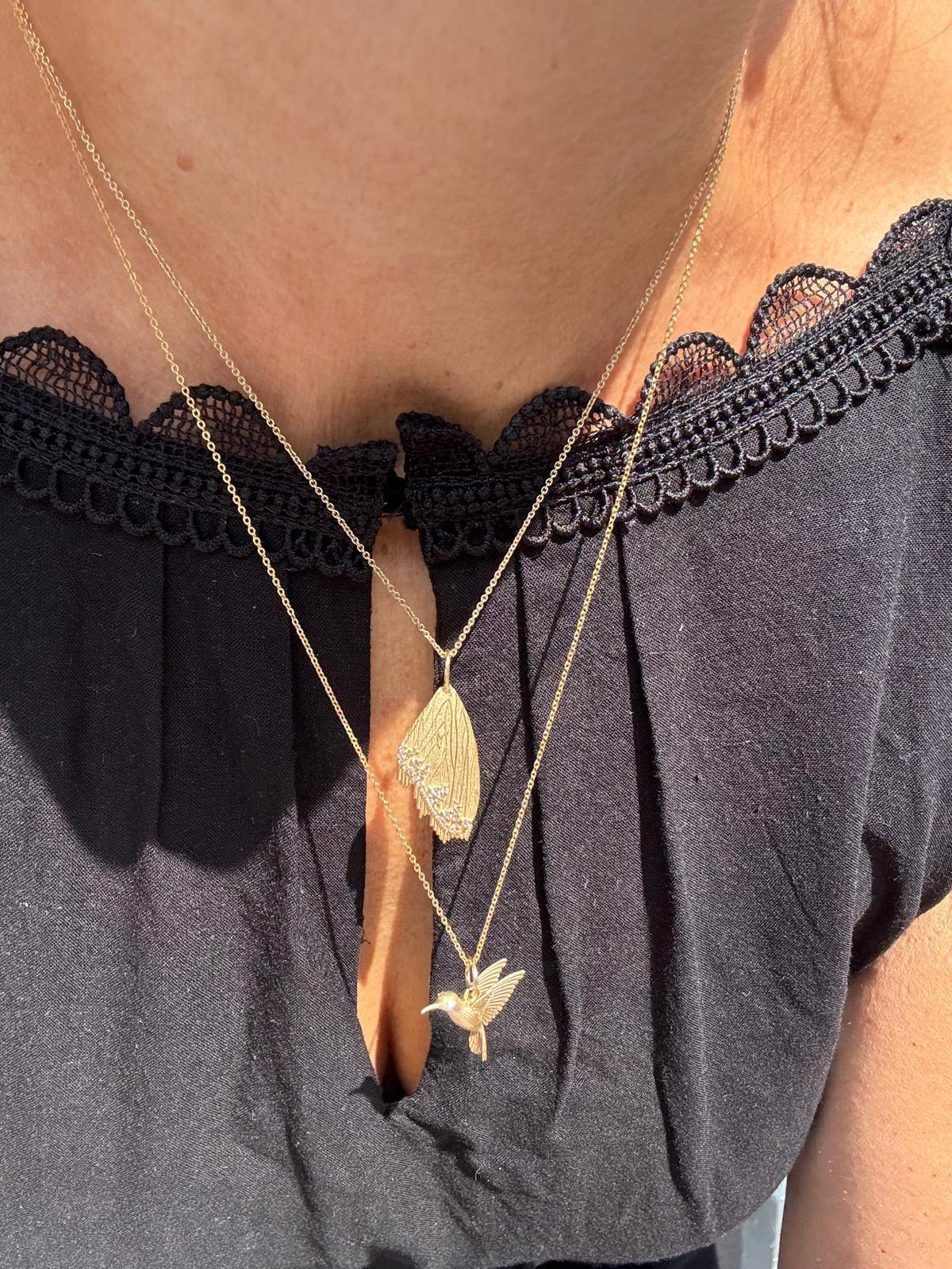Un véritable pendentif scintillant et délicat qui attire le regard ; cette aile de papillon ludique est entourée de diamants roses étincelants qui captent la lumière de manière éblouissante. Il s'agit d'un bijou minimaliste et intemporel qui peut se