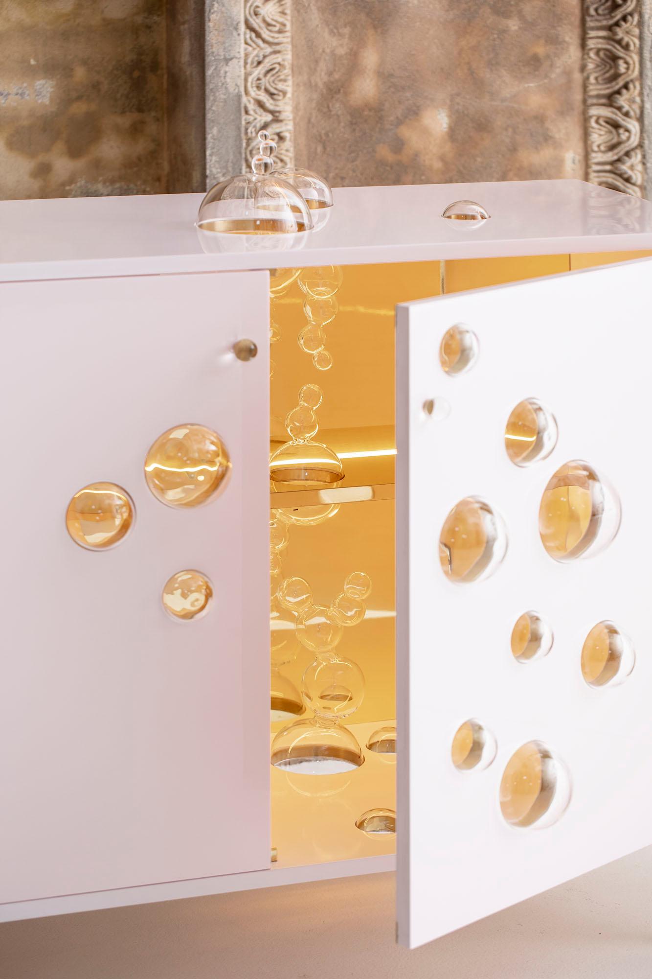 Sparkling cabinet ist ein einzigartiges Projekt, bei dem der Künstler ironisch mit Glas spielt und eine brillante und originelle Dekoration schafft.

Hergestellt in einem Stück aus rosa lackiertem Holz mit Messingdetails und Borosilikatglas.
Im