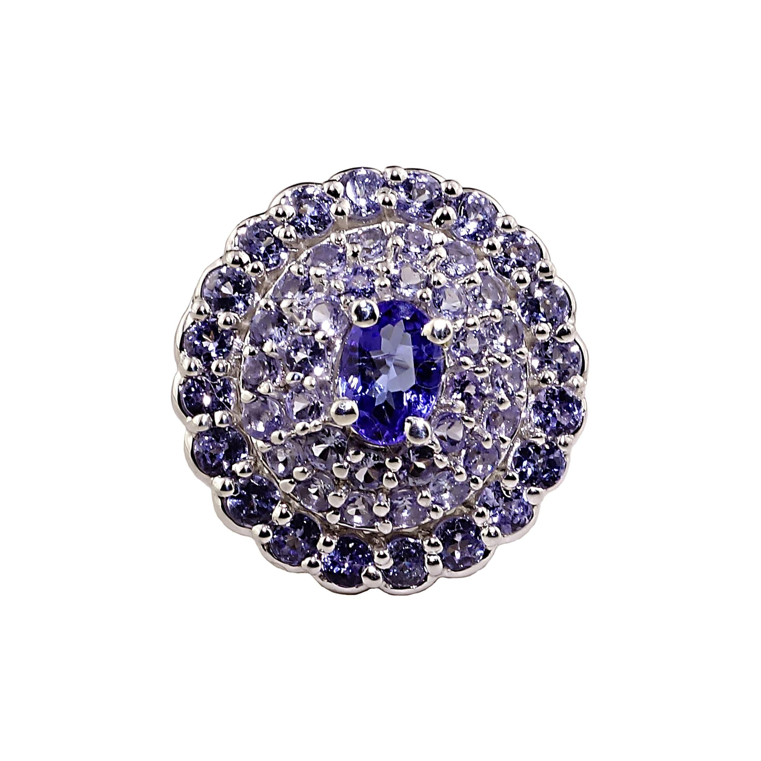 Unique ring of glittering Tanzanites, lots of Tanzanites! Deep blueish/purple oval center stone of 7x5 mm is surrounded by a halo of three rows of sparkling lavender Tanzanites (3.16ct). This is 3/4 of an inch across your finger of glitter.  What a