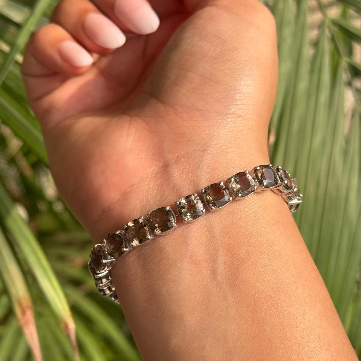 Esta pulsera de plata con topacio ahumado y piedra de nacimiento de noviembre tiene una hilera continua de gemas de cuarzo ahumado en talla cojín engastadas en luminosa plata de ley 925. Cada piedra está firmemente engastada para maximizar el brillo