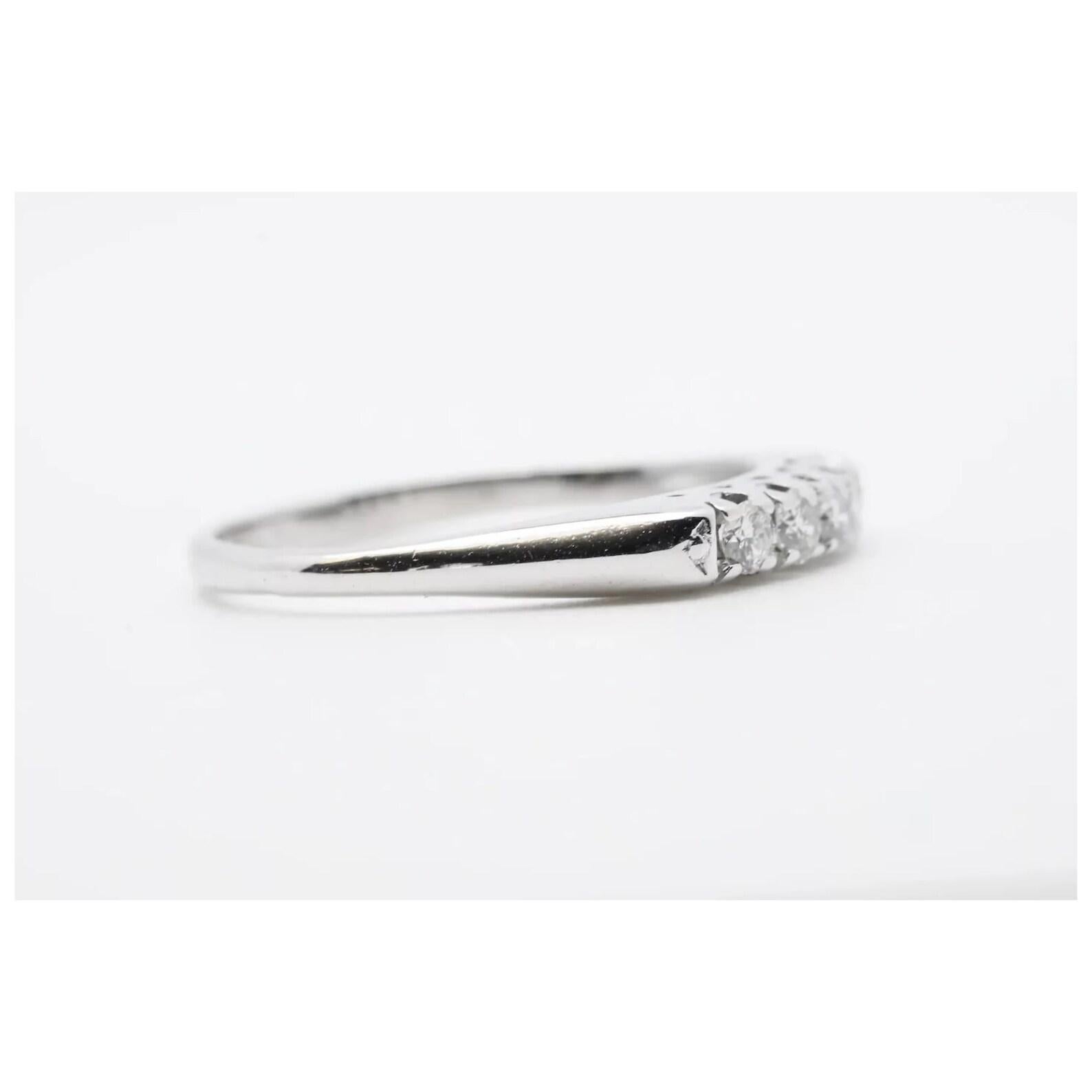 A vintage 1950's mid century platinum and diamond wedding band. Set with five round brilliant cut diamonds weighing a combined 0.20 carats. The diamonds grade as G color, VS1 clarity and are secured by shared platinum prongs.

In excellent