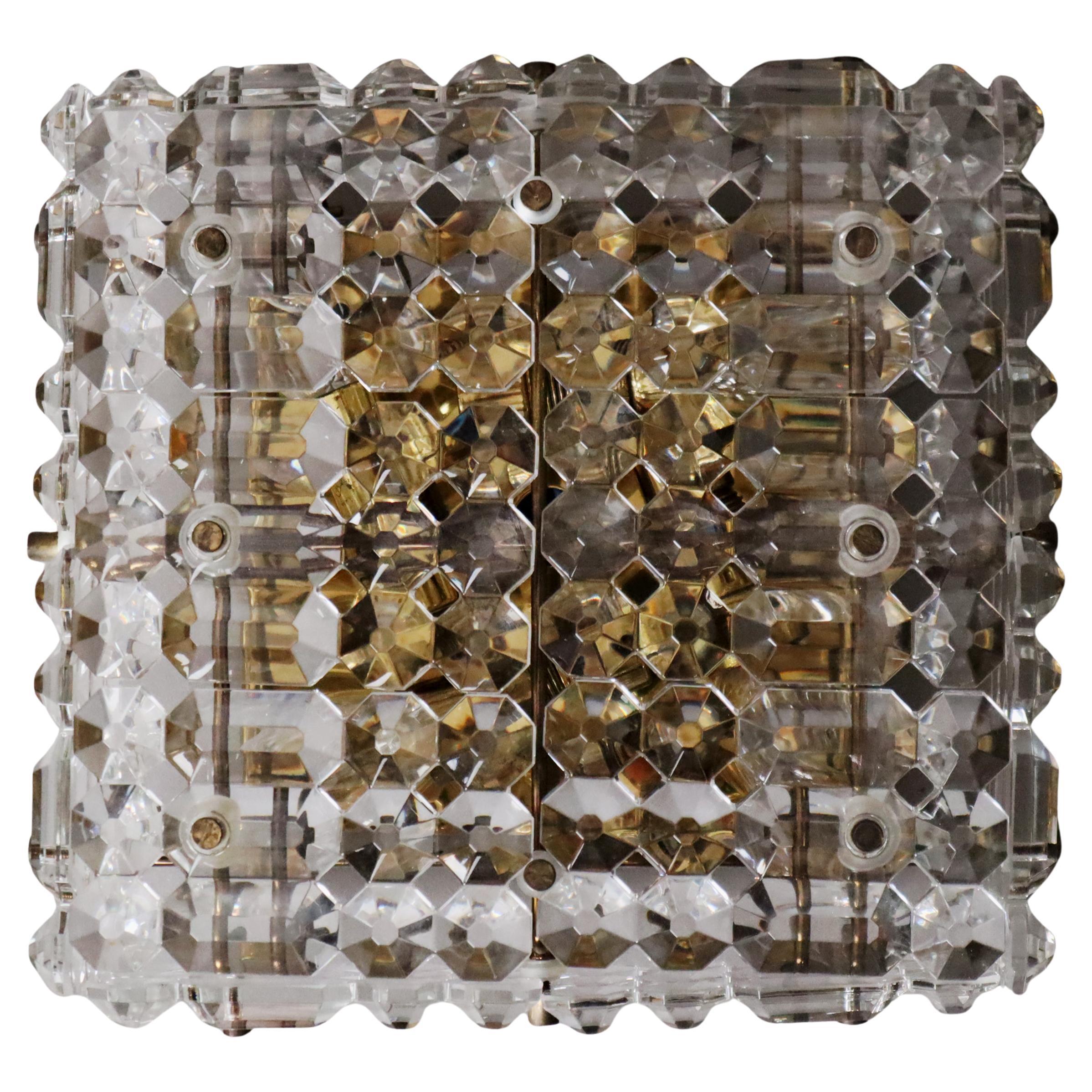 L'applique Kinkeldey est une pièce unique composée de quatre ampoules. Sa lumière est spéciale car elle est plaquée or, la lumière frappe la plaque dorée et atteint les verres de cristal qui prennent alors une teinte jaune d'or. Il s'agit