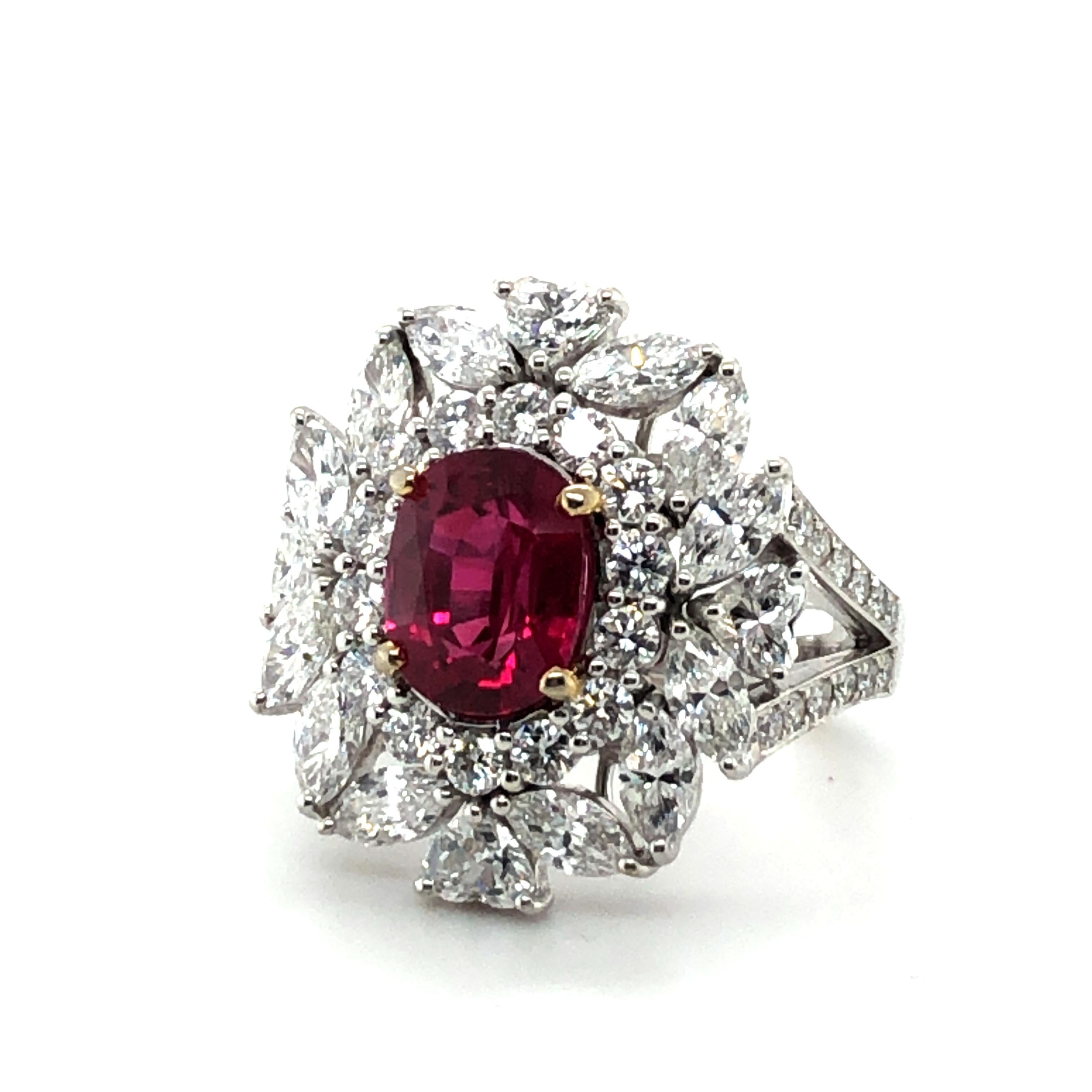 This beautiful ring in 18 karat white gold is set with an oval-shaped ruby of 2.65 carats in a bright red. 
The charming entourage consists of 12 marquise-shaped, 4 heart-shaped, and 38 brilliant-cut diamonds of G/H colour and vs clarity, total