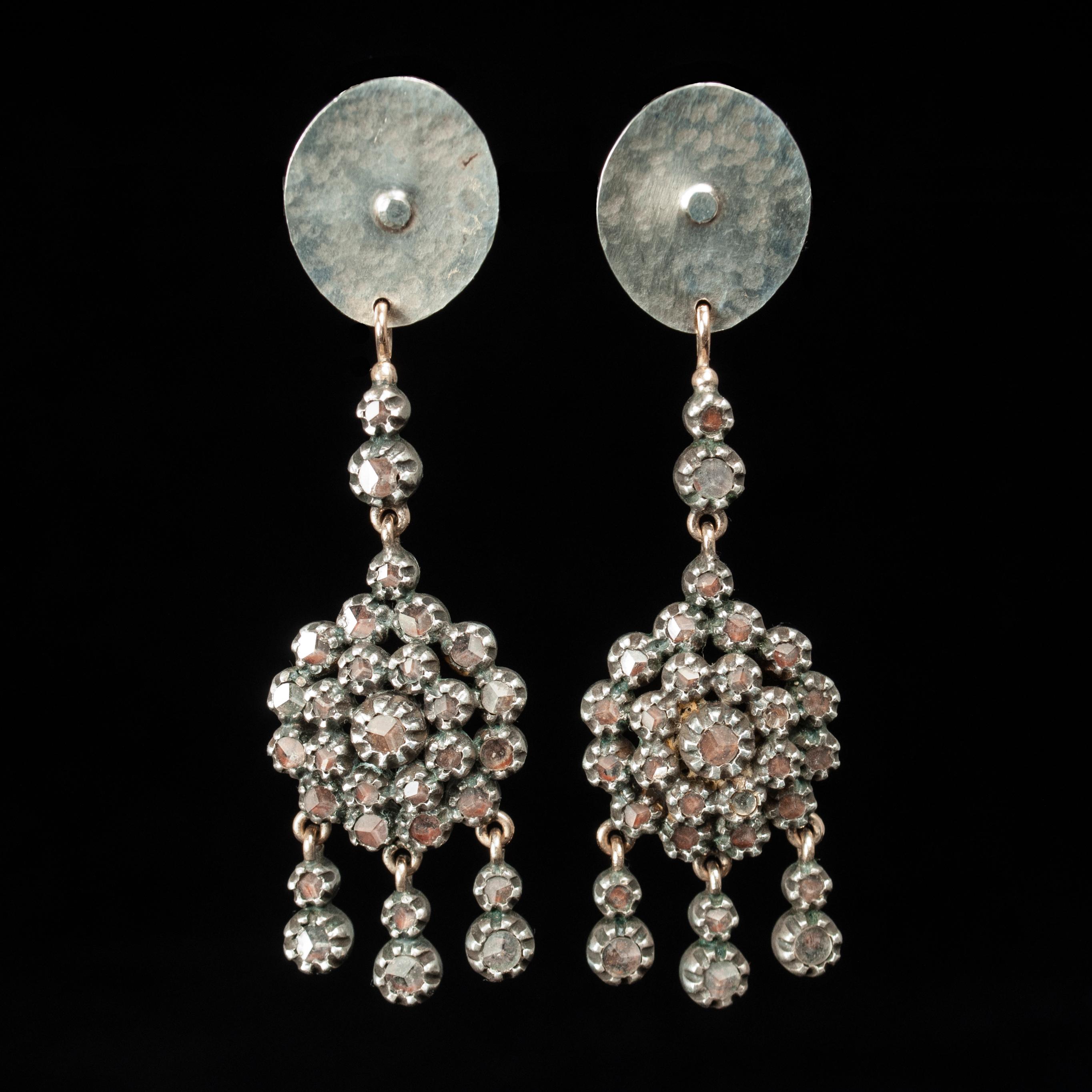 Sparkling silver and glass south Indian drop earrings by Jewels

A pair of sparkling drop earrings by Jewels of Santa Fe/Marrakesh, composed of cut glass with a slight pink tone set in silver from South India, attached to a hand-hammered oval