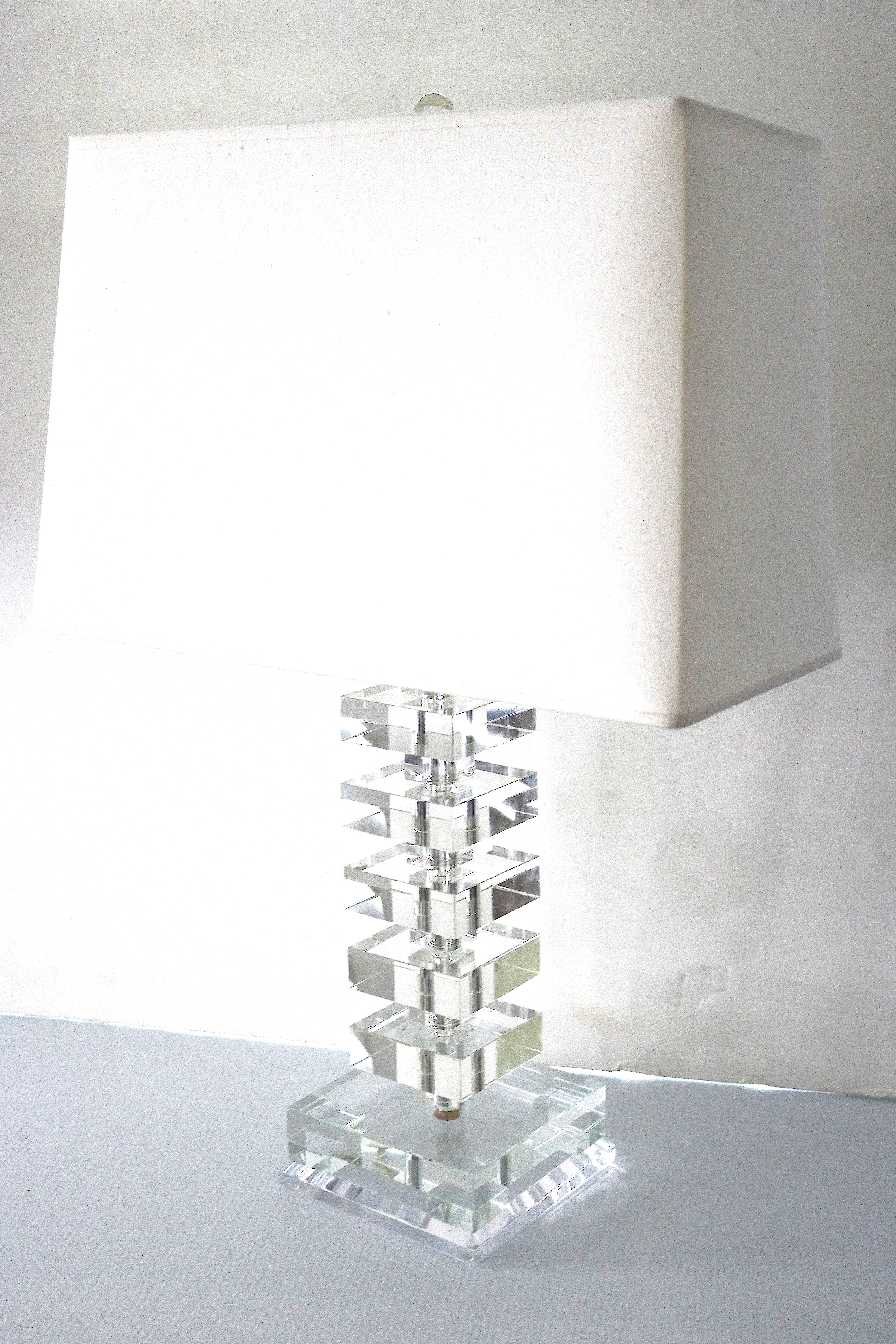 Two Sparkly crystal stacked block table lamps in stylish Orrefors graphic glam geometric forms!
Gershwin tunes, diamonds and sables. At home amidst the unapologetic decadence of the smoldering Jazz Age, this modern table lamp evokes an era when