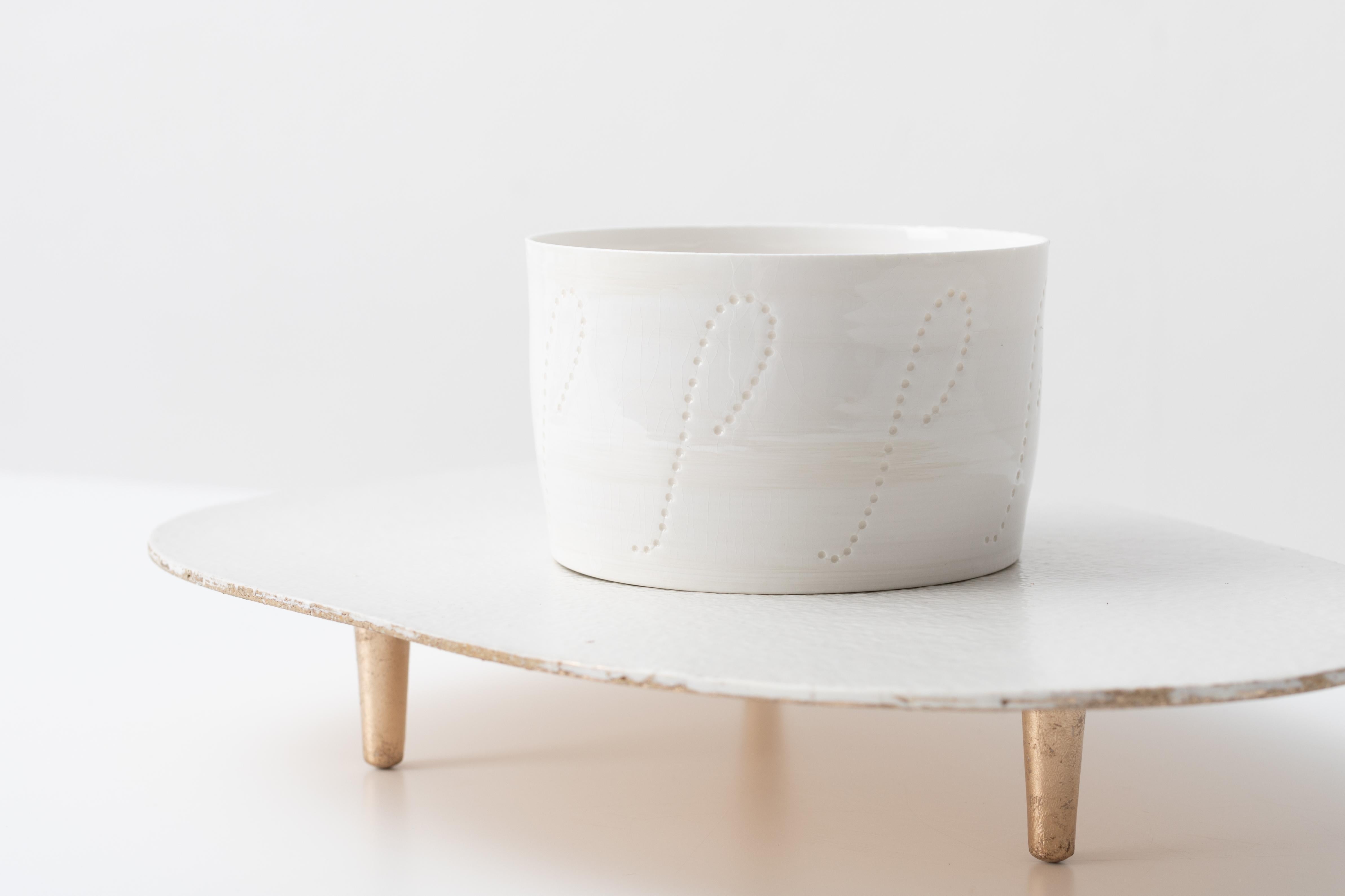 a porcelain vessel on a glazed and gilded ceramic plinth by London artist Christopher Riggio