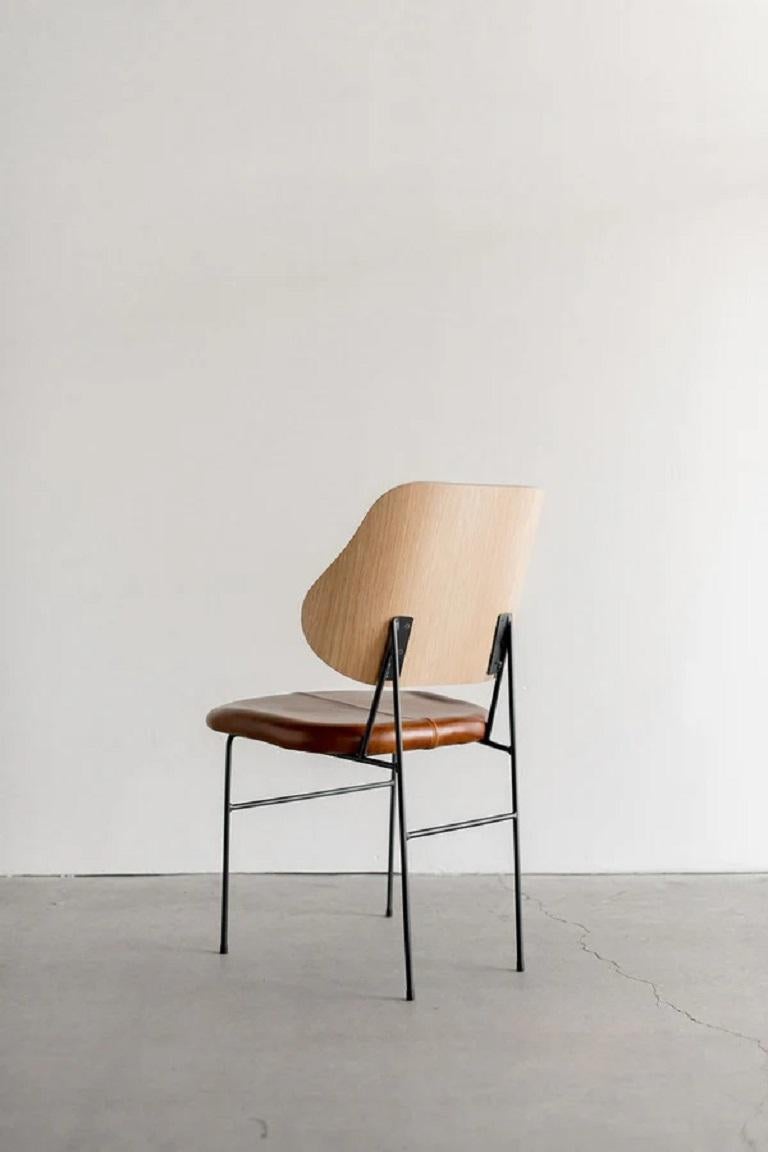 Unsere Interpretation des klassischen Penguin Chair von Ib Kofod-Larsen. Dieser Esszimmerstuhl wird in Los Angeles maßgefertigt. Der Metallrahmen ist geschweißt. Der Rücken aus Eichenholz wird von Hand gebogen und in Form gebracht. Gepolsterter
