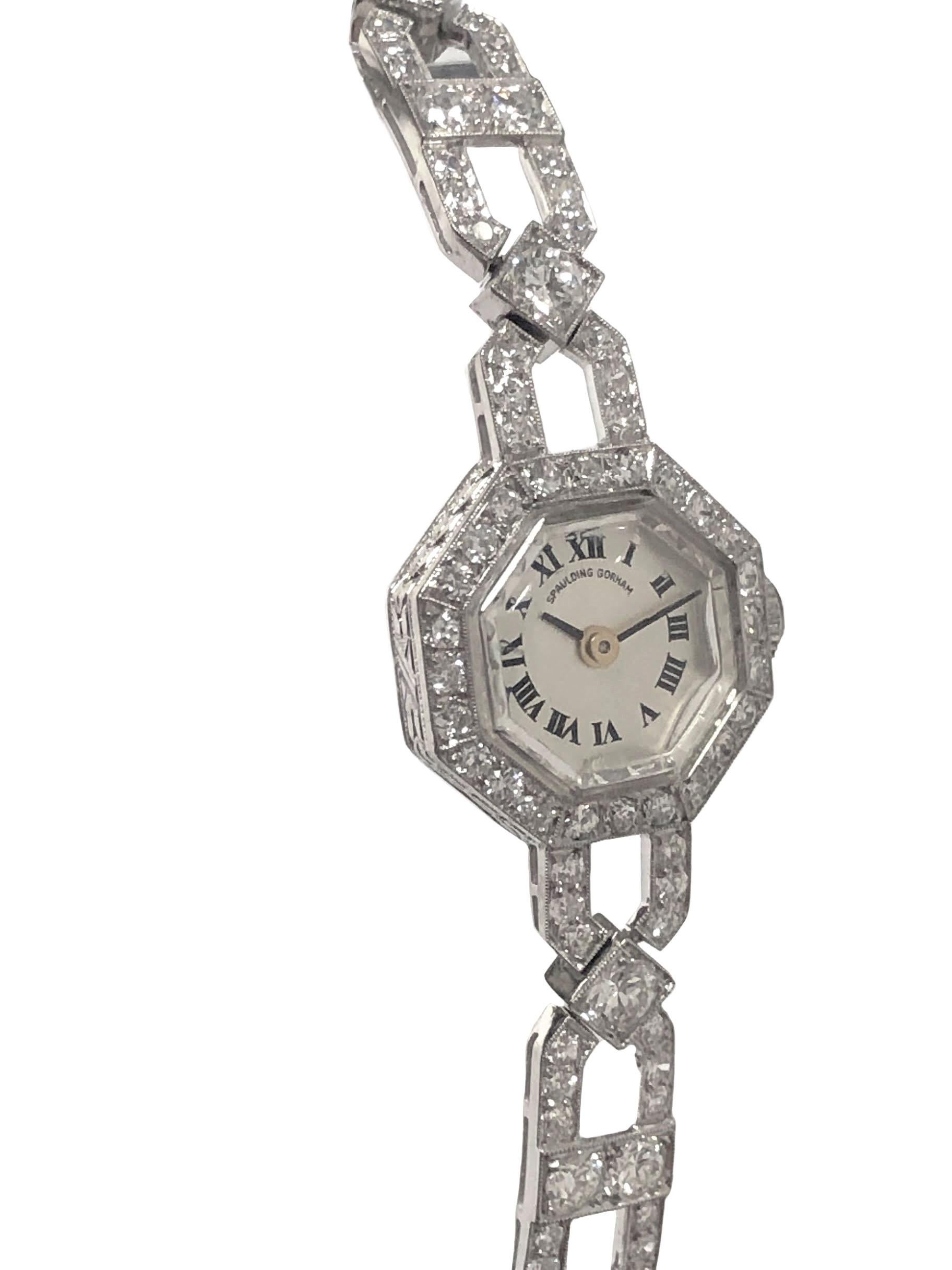 Circa late 1920s Ladies Platinum Bracelet watch Retailed by Spaulding Gorham, 16 M.M. octagon shape 2 piece case with hand engraved design work, Diamond set crown. 17 Jewel Mechanical, manual wind movement by Schultz. Silver Satin dial with Black
