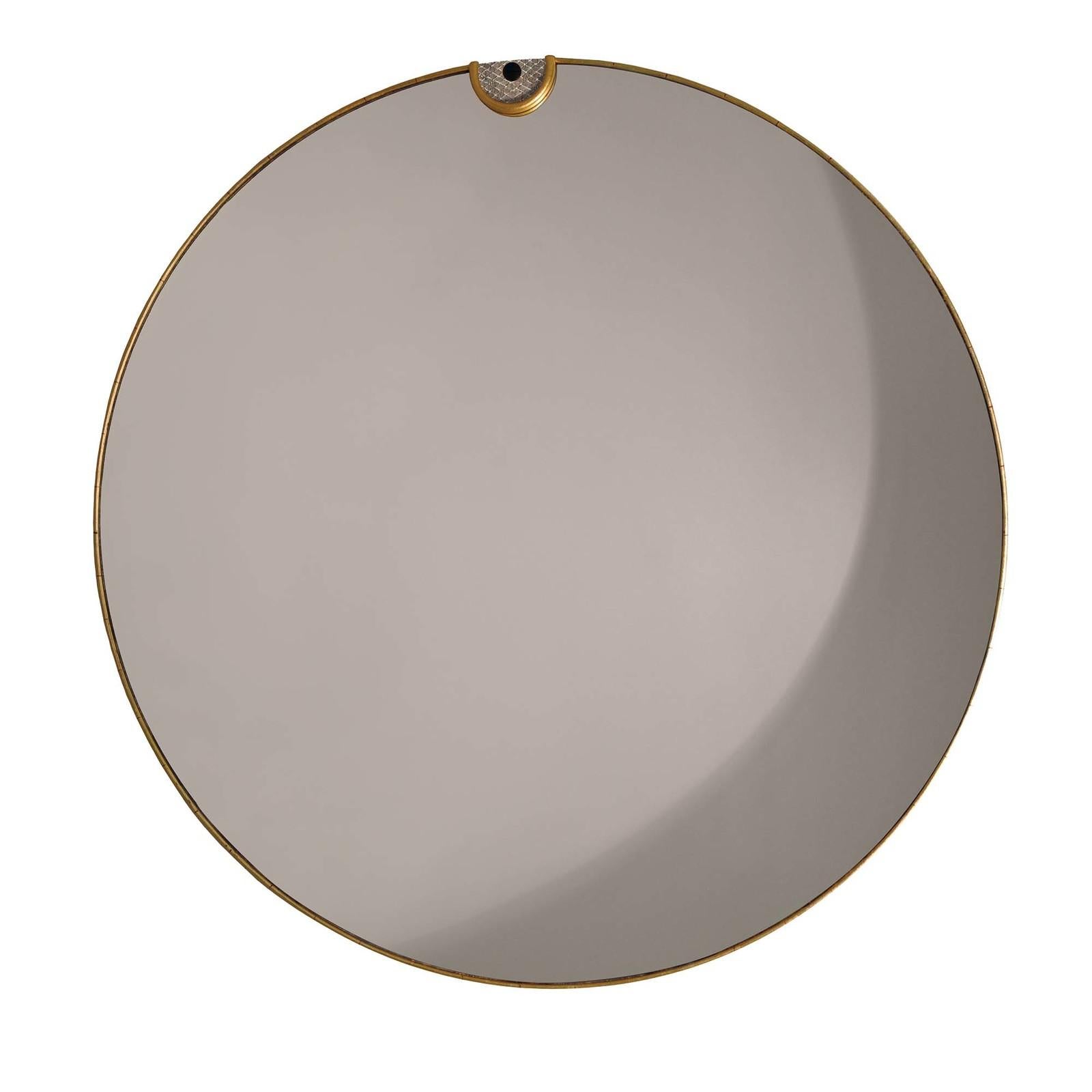 Elegant and sophisticated, this round wall mirror features a minimal oak frame adorned with gold leaf and embellished on top with a semicircular detail in stained cork with a pattern evoking fish scales. Taking center stage on a bare wall in an