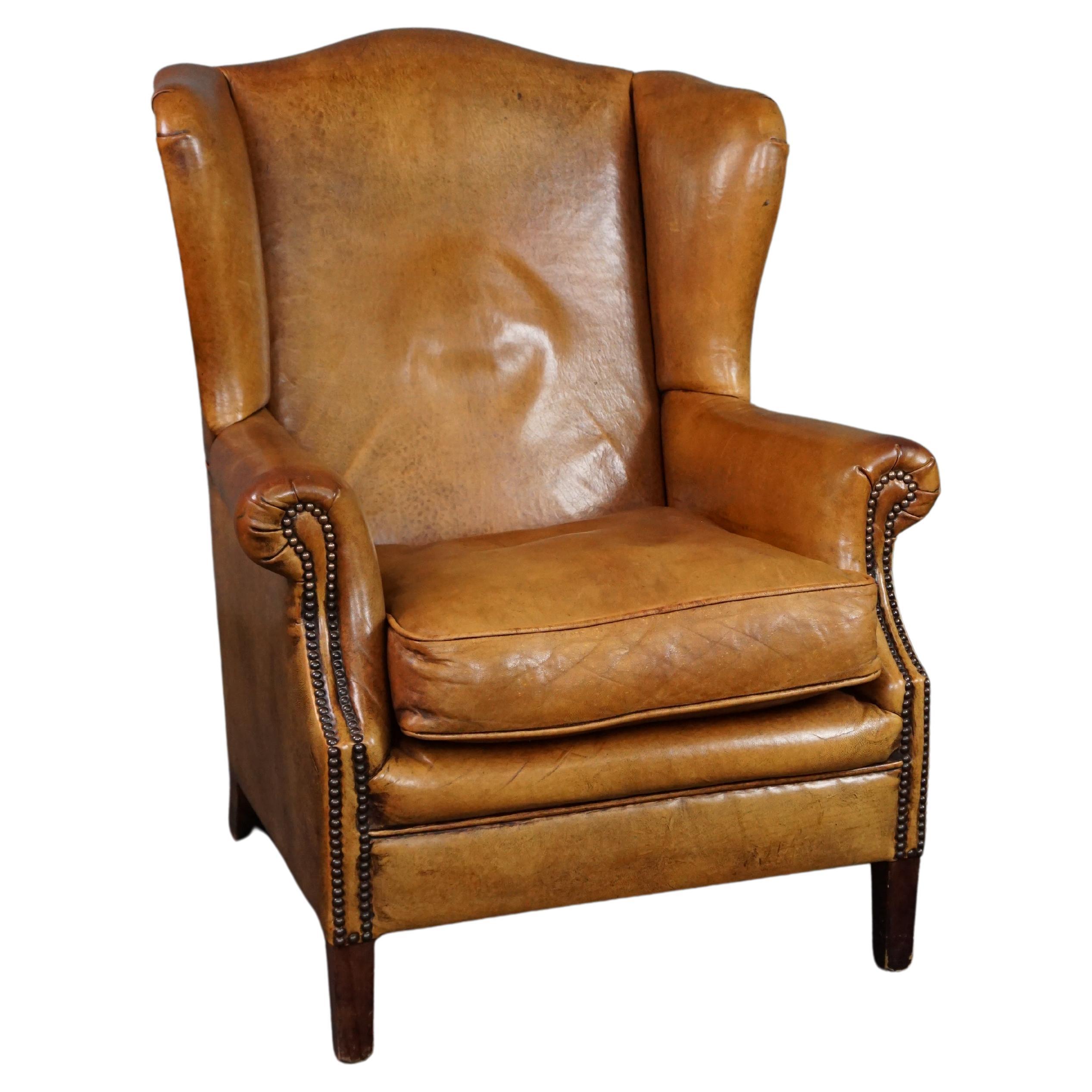 Speaking cognac colored sheep leather wing armchair For Sale