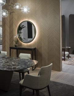 Espejo circular globo con borde revestido de cuero y costuras visibles