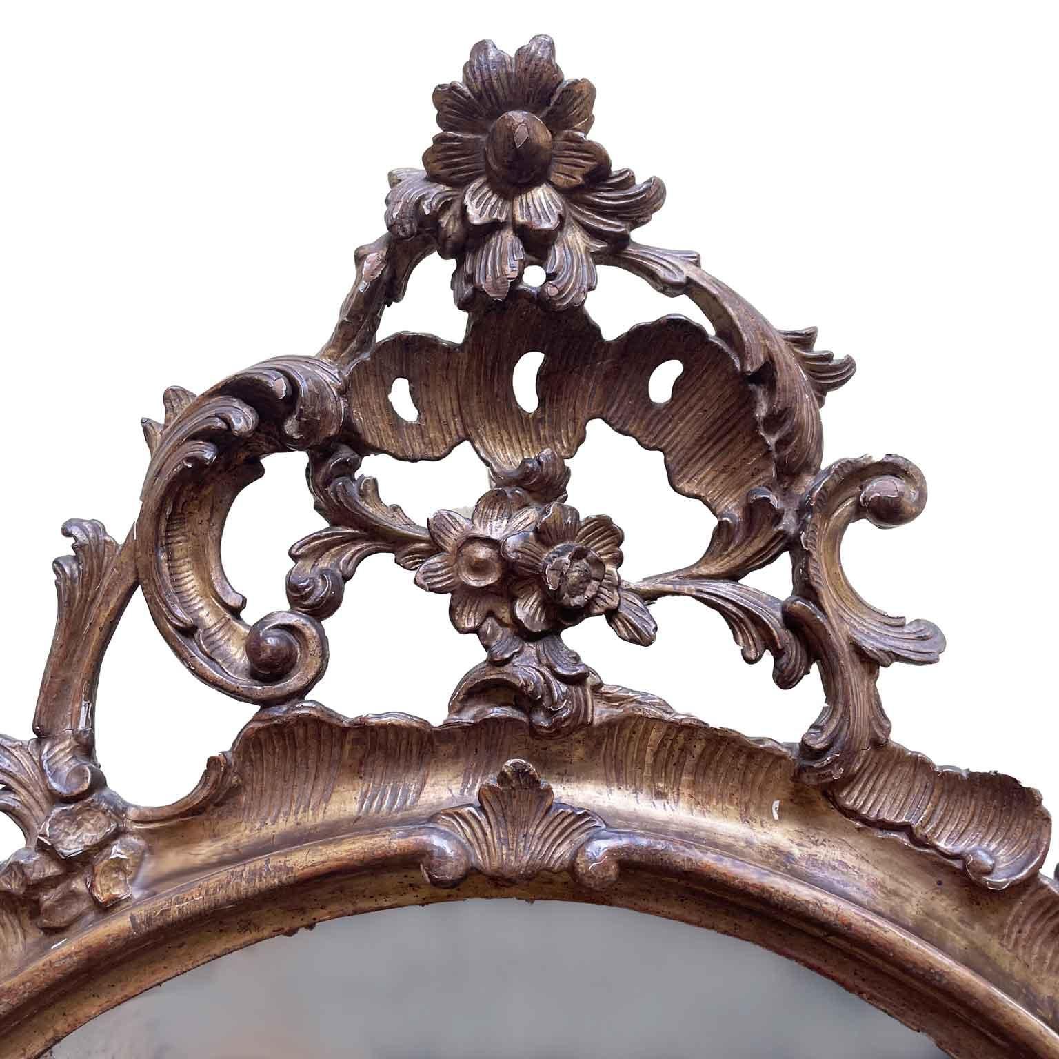 Italian carved and gilded wooden leaf mirror from the mid-1800s, Louis Philippe style,  elaborate carving with plant motifs and scrolls, tall pierced cyma and mercury mirror. Good overall state of preservation apart from minimal shortcomings
