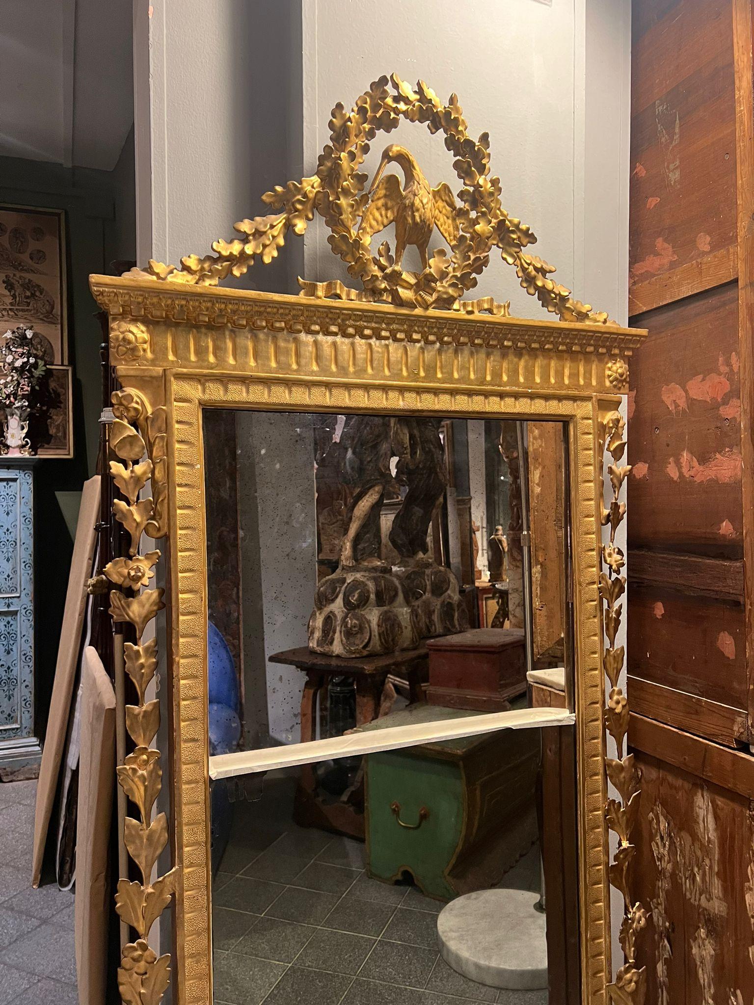 Beautiful carved and gilded wooden mirror, dating from the very early 18th century and originally from Livorno. 

Very fine gilding and carvings in the cymatium. Peculiarity is in the mirror, which is mounted in two pieces. 

Dimensions: 5x85x188 cm 