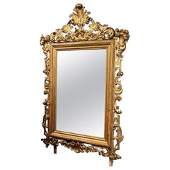 Miroir en bois sculpté et doré, avec une riche corniche, XIXe siècle