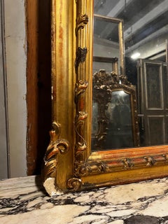 A carved and gilded mirror in the Second Empire style from the late 19th century.