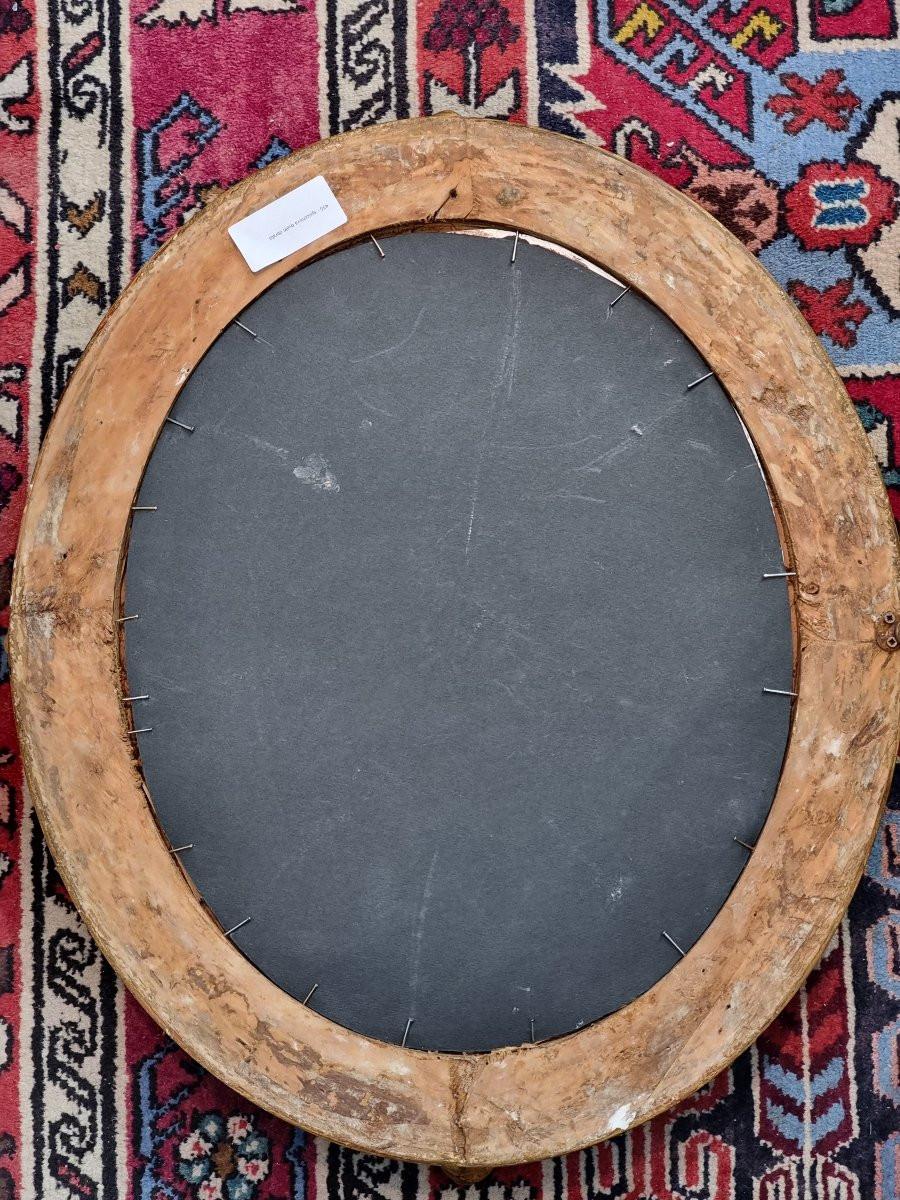 Elegante specchiera ovale proveniente dal Piemonte, realizzata in legno di tiglio finemente intagliato e dorato a foglia oro. L’oggetto, di dimensioni contenute (57 cm di larghezza massima per 48 cm di altezza), si distingue per la raffinatezza