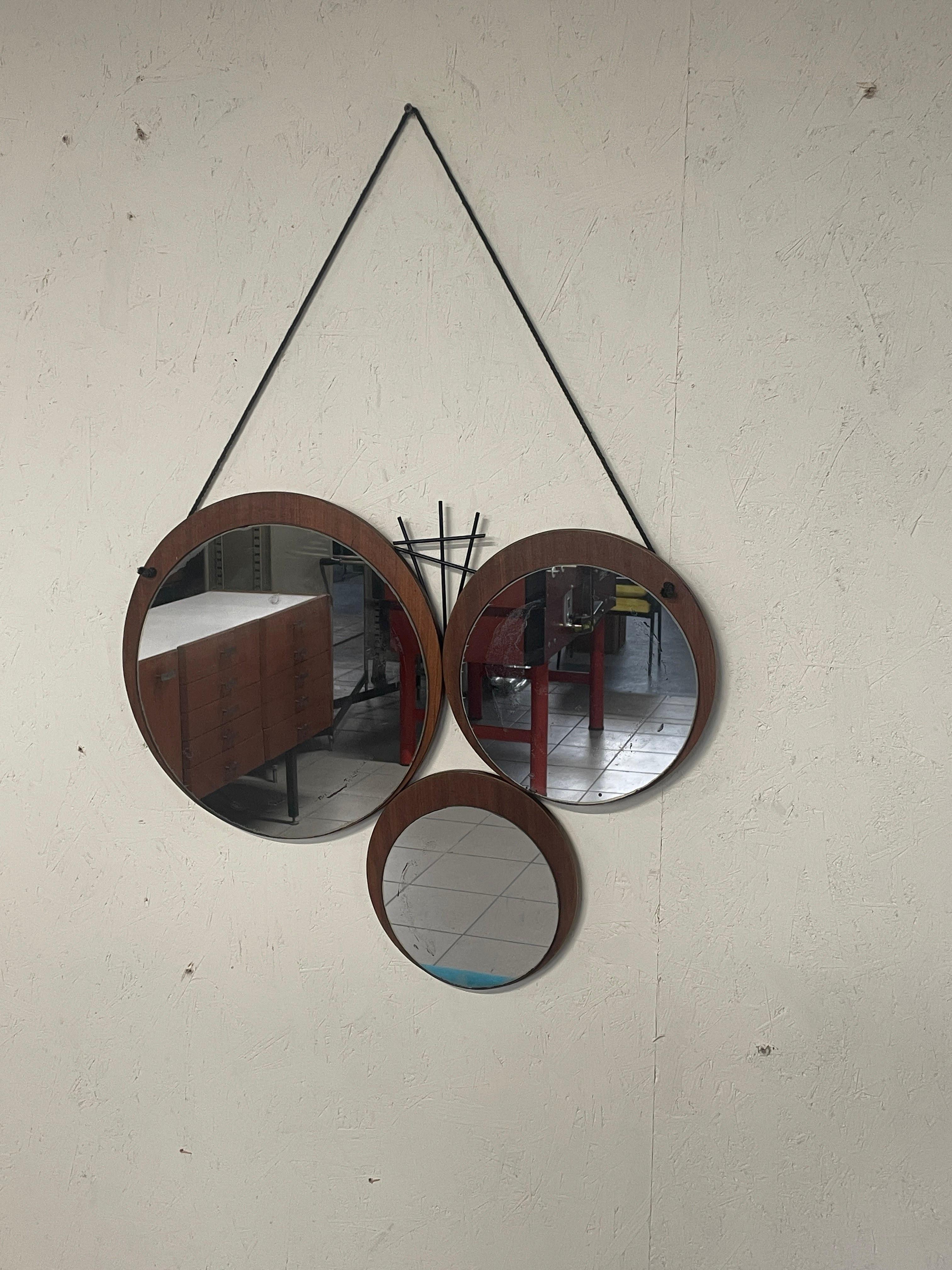 1960s mirror composed of three round teak circles of various sizes with as many mirrors inside.

The 3 circles are combined with a black metal motif.

Complete with original leather lanyard.

Very good condition given age and use.