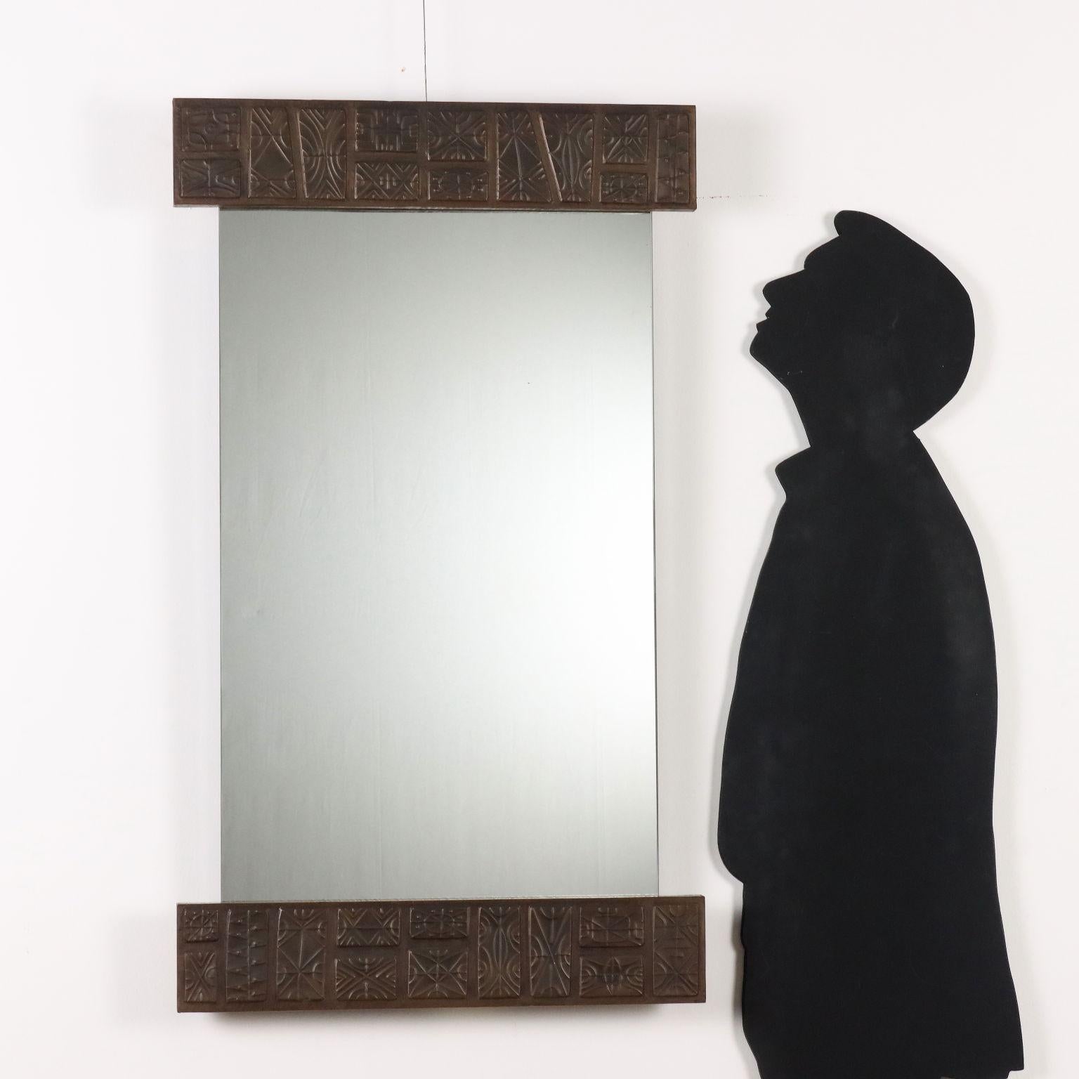 Specchio vintage da parete di forma rettangolare e di manifattura italiana con particolare decorazione in rame sbalzato sulla parte superiore e inferiore.