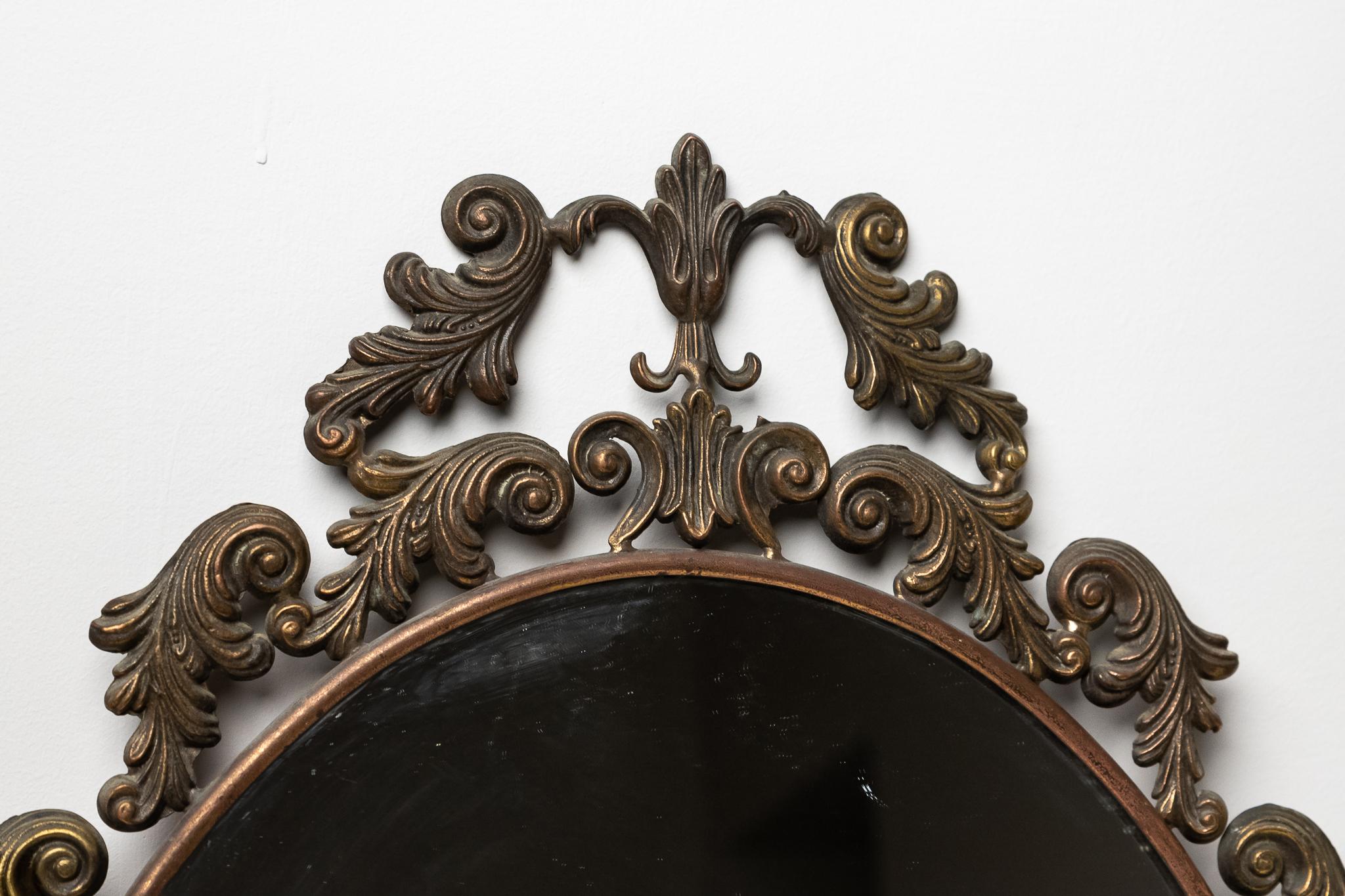 Miroir baroque en bronze, fabriqué en Italie, années 1930. 
Miroir mural de style baroque en bronze du début du 20e siècle.
Le miroir et le cadre sont ORIGINAUX et conservent la patine du temps. 
Il peut présenter de légers signes d'usure dus au