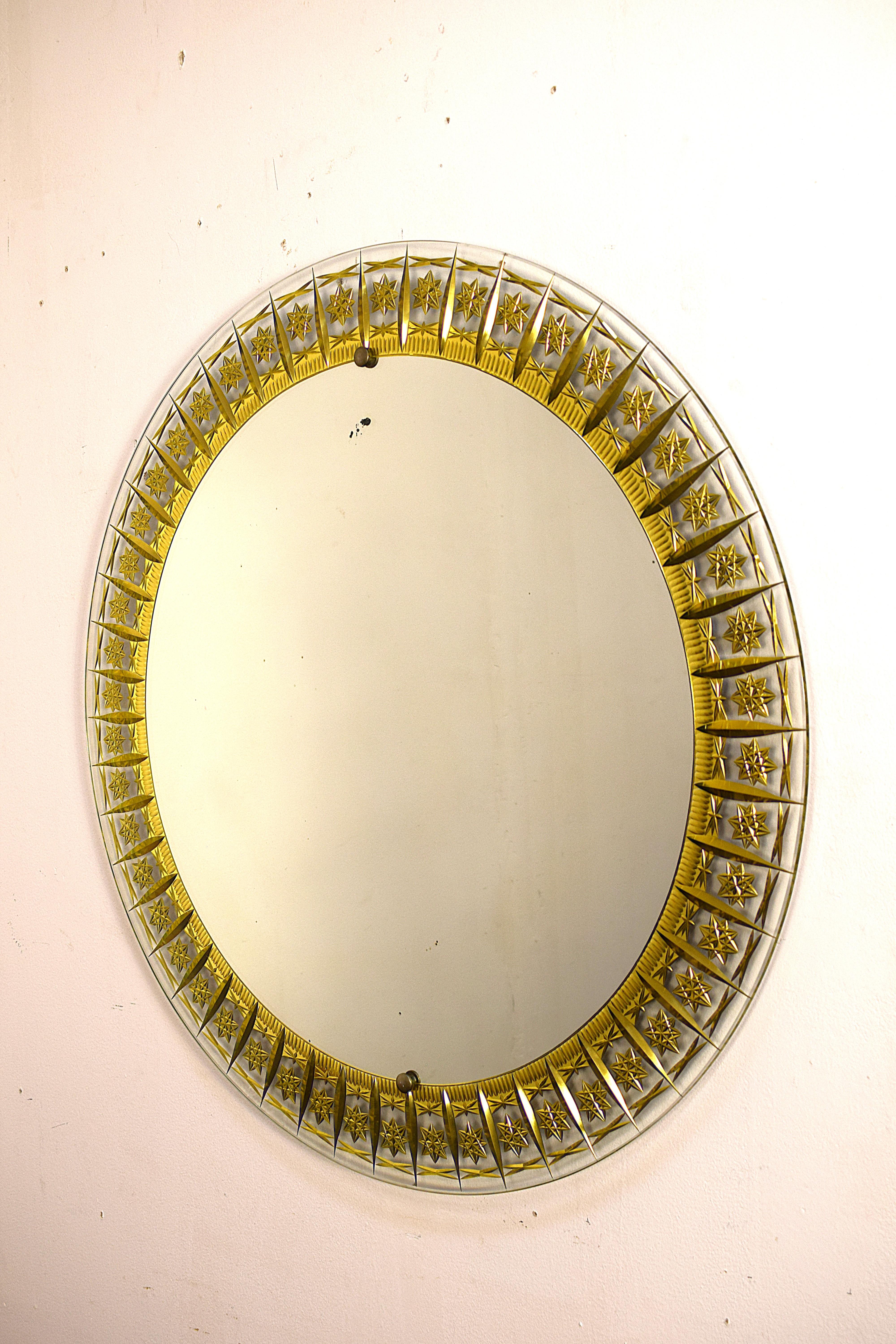 Elegante specchio circolare originale Cristal Art, realizzato in Italia negli anni '50. Con un diametro di 70 cm e una profondità di 3 cm, rappresenta un perfetto esempio di design mid-century italiano. La superficie è composta da vetro inciso e