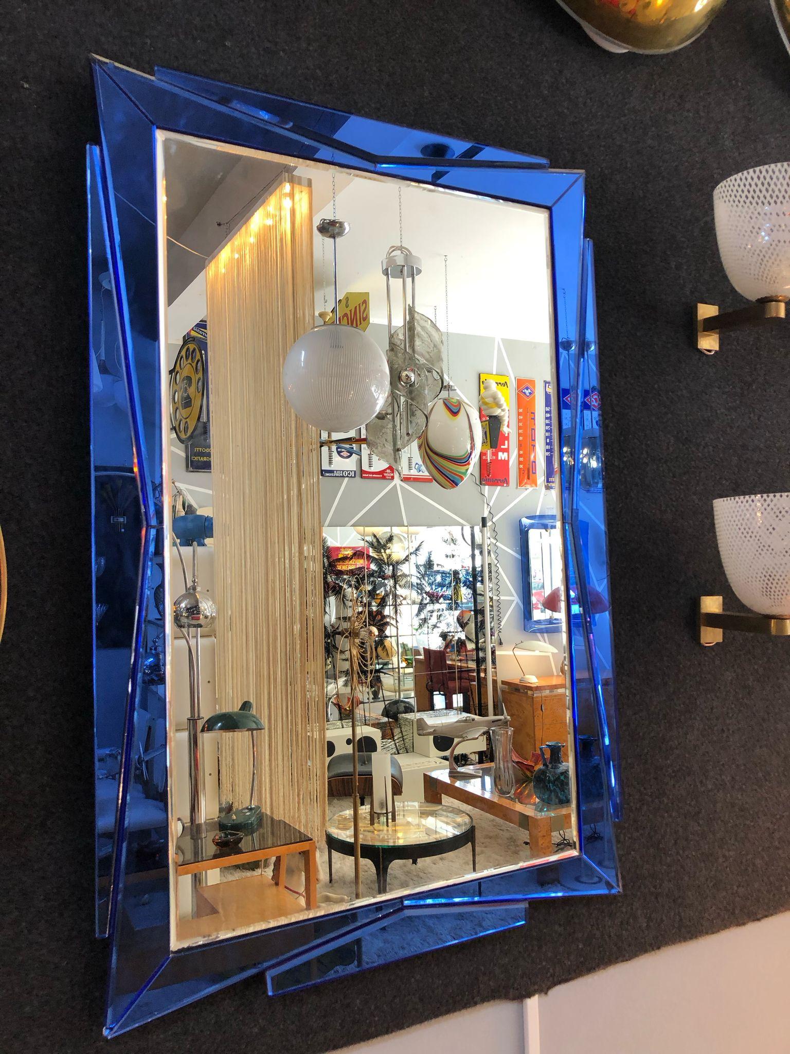 This Cristal Art mirror is an iconic example of the eclectic and visionary taste that defined Italian design in the 1960s. Its frame, made of faceted glass in an intense cobalt blue (typical of this company), is articulated in sloping planes and
