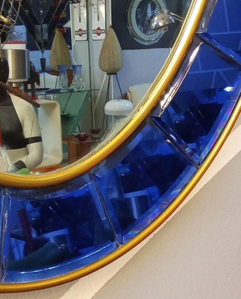 Bellissimo specchio ovale Cristal Art anni '60 con cornice di cristallo blu intenso tagliata a mano e smussata, doppio bordo in ottone dorato e vetro a specchio.

