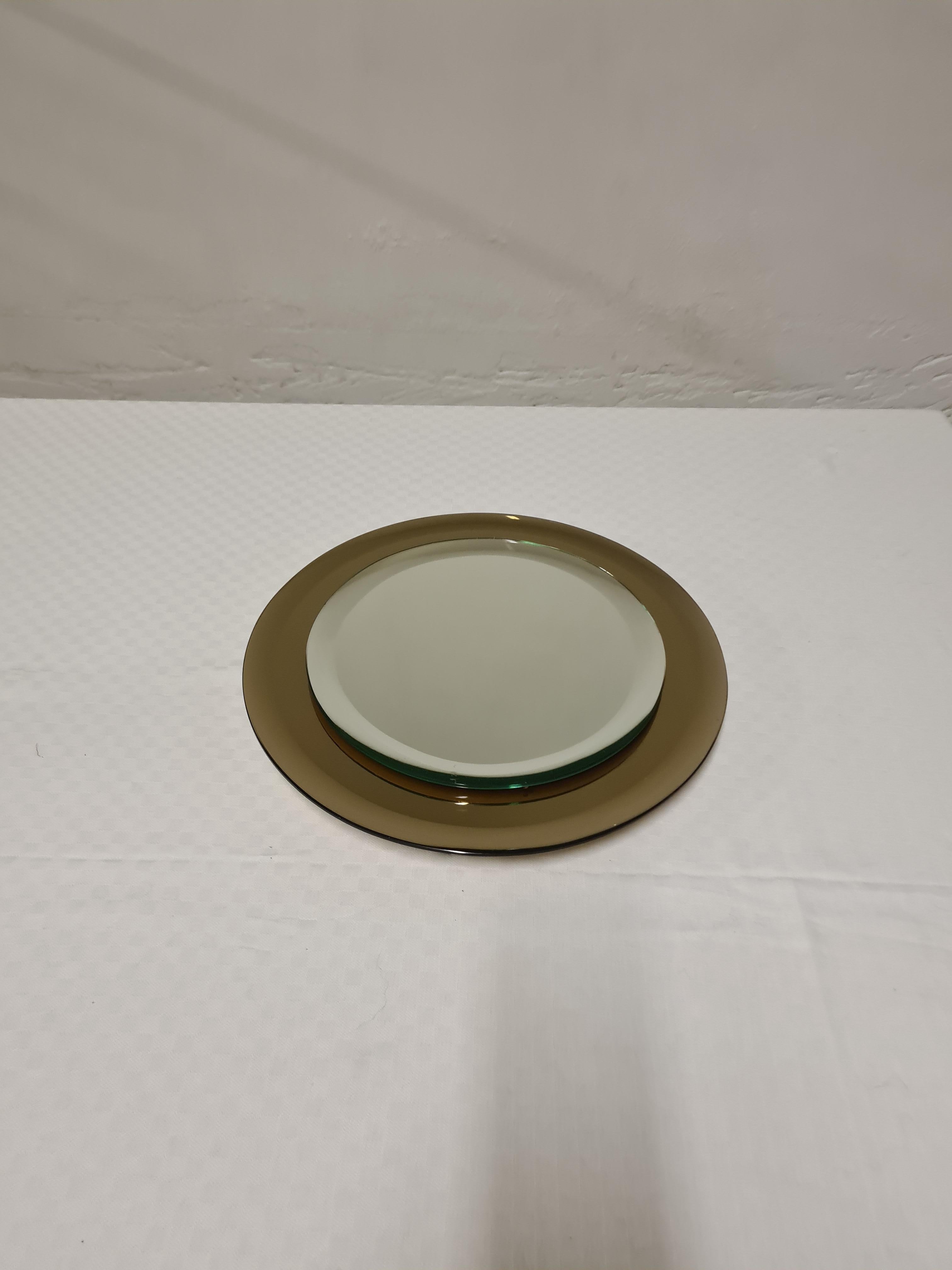 Miroir rond d'Antonio Lupi.

Petit miroir avec miroir central biseauté et cadre en verre de fumée miroité.

Conçue et produite par Cristal Lupi Luxury, une entreprise fondée dans les années 1950 par le tout jeune Antonio Lupi, spécialisée dans la