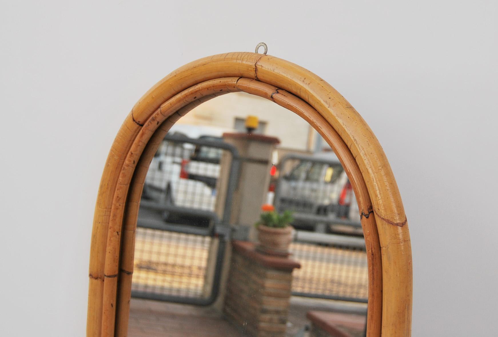 Beautiful arched wall mirror, made of bamboo and rattan, Made in Italy, 1960s. 
Can be mounted on the wall. 
The price of shipping is for the Italian territory, for the islands and for shipping abroad quote on request. 
Customs expenses are to be