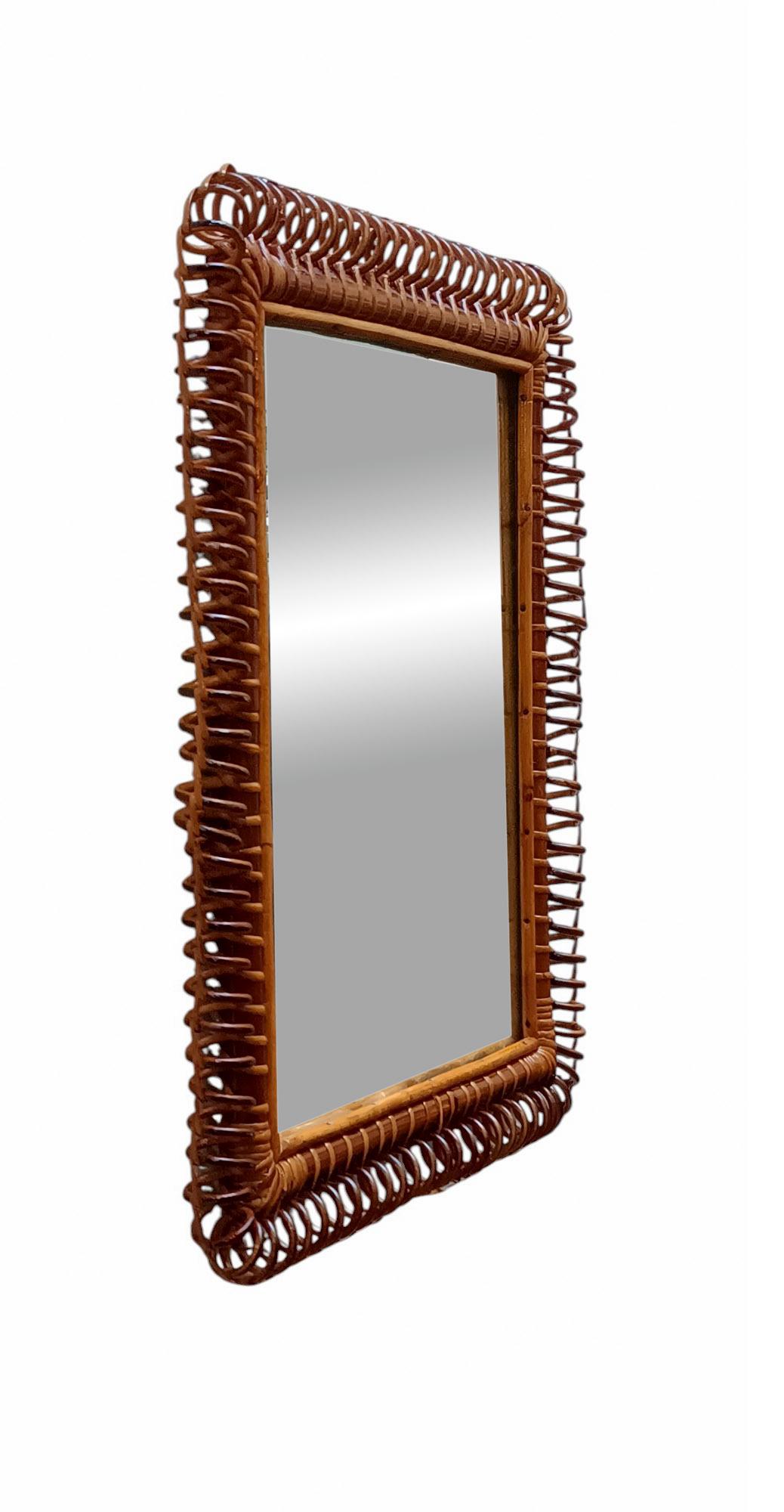 Spectaculaire miroir rectangulaire fait à la main en bambou, rotin et osier courbé. 
Il a une forme rectangulaire enrichie tout autour par une spirale de rotin courbée. La structure est complétée par un magnifique tressage d'osier sur le dessus et