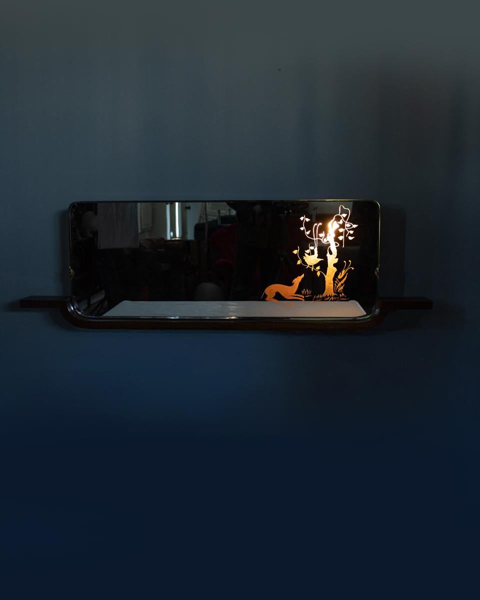 Specchio da parete con struttura in legno, vetro con decori retroilluminati, design Italiano, anni 40.

DIMENSIONI: 
Altezza 47 cm; Larghezza 153 cm; Lunghezza 10 cm

MATERIALI: 
Legno e vetro

ANNO DI PRODUZIONE: 
Anni 40
