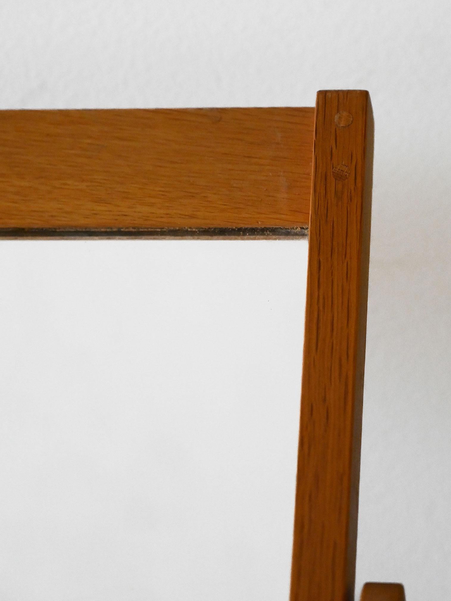 Swedish 1960s mirror with light teak frame and tilting stand, manufactured by Fröseke.

Table mirror manufactured by Fröseke, Sweden, in the 1960s. Adjustable natural teak frame with light, geometric lines designed to combine functionality and