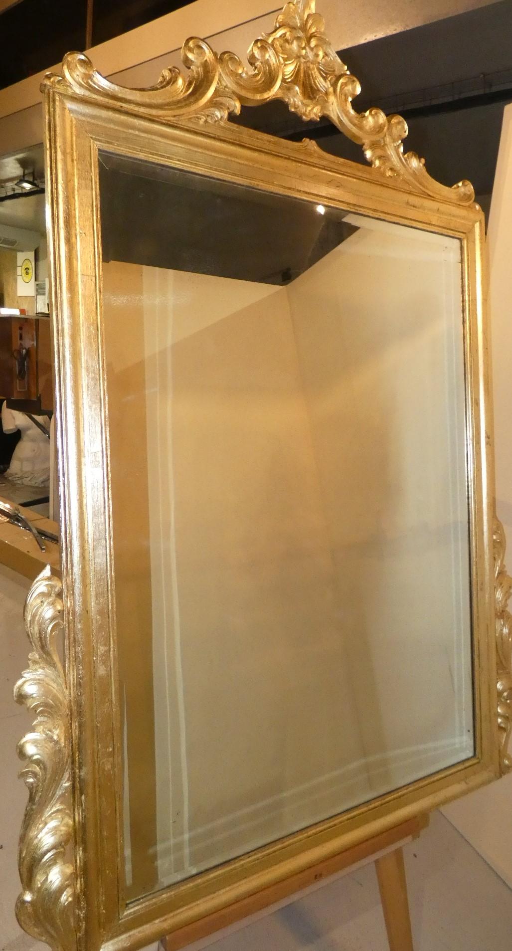 Prezioso specchio dei primi '900, con cimasa, volute laterali e decori a ricciolo. Restaurato e rifinito in foglia oro e lacca.

Dimensioni: H. 164,5 cm - L. 112 cm - P. 4,5 cm.  Dimensioni interne: H. 118 cm - L. 81,5 cm