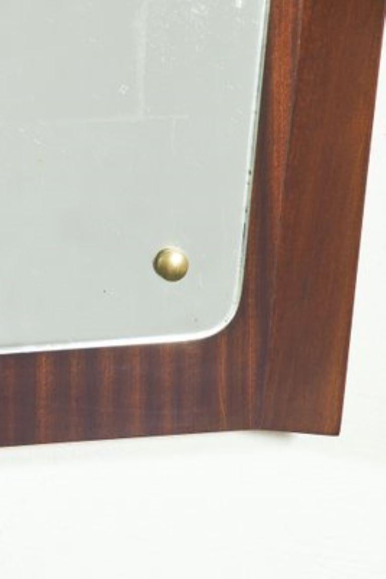 Eleganter geschwungener Holzspiegel aus den 1950er Jahren, der Holzteil wurde restauriert, der Spiegel ist original, er hat Lichthöfe im Spiegel, weil er original aus der Zeit ist.