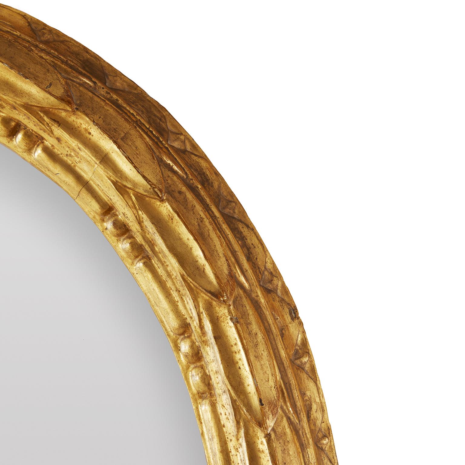 Italian Miroir italien ovale à feuilles sculptées et dorées Milieu du 20e siècle en vente