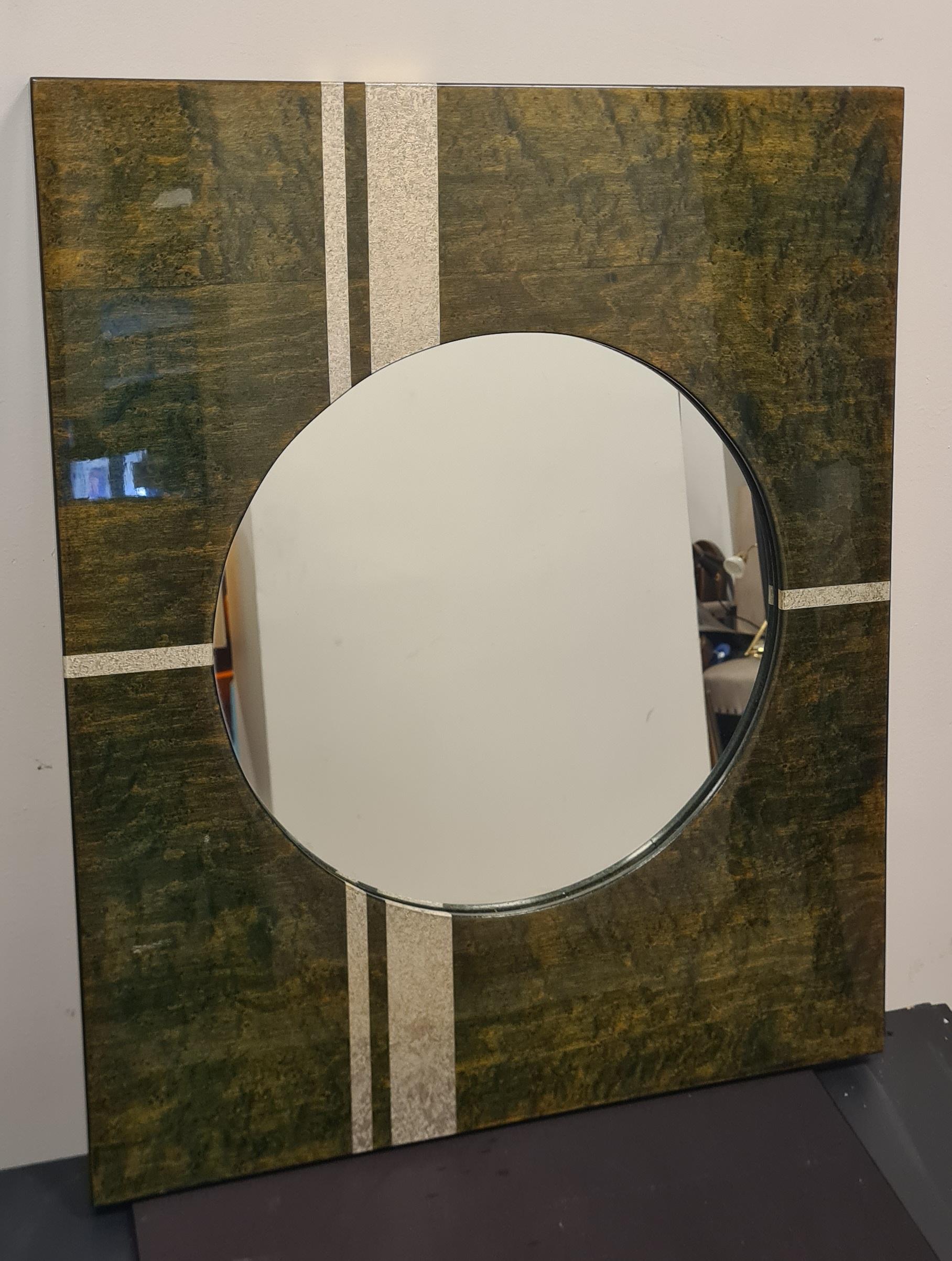 Specchio dalla forma e lo stile stipo degli anni 70'.

Lo specchio è di forma rotonda con una cornice rettangolare in legno laccato verde e decorazioni argentate.

Ideale per un ingresso o un bagno questo specchio donerà colore ed uno stile retrò ai