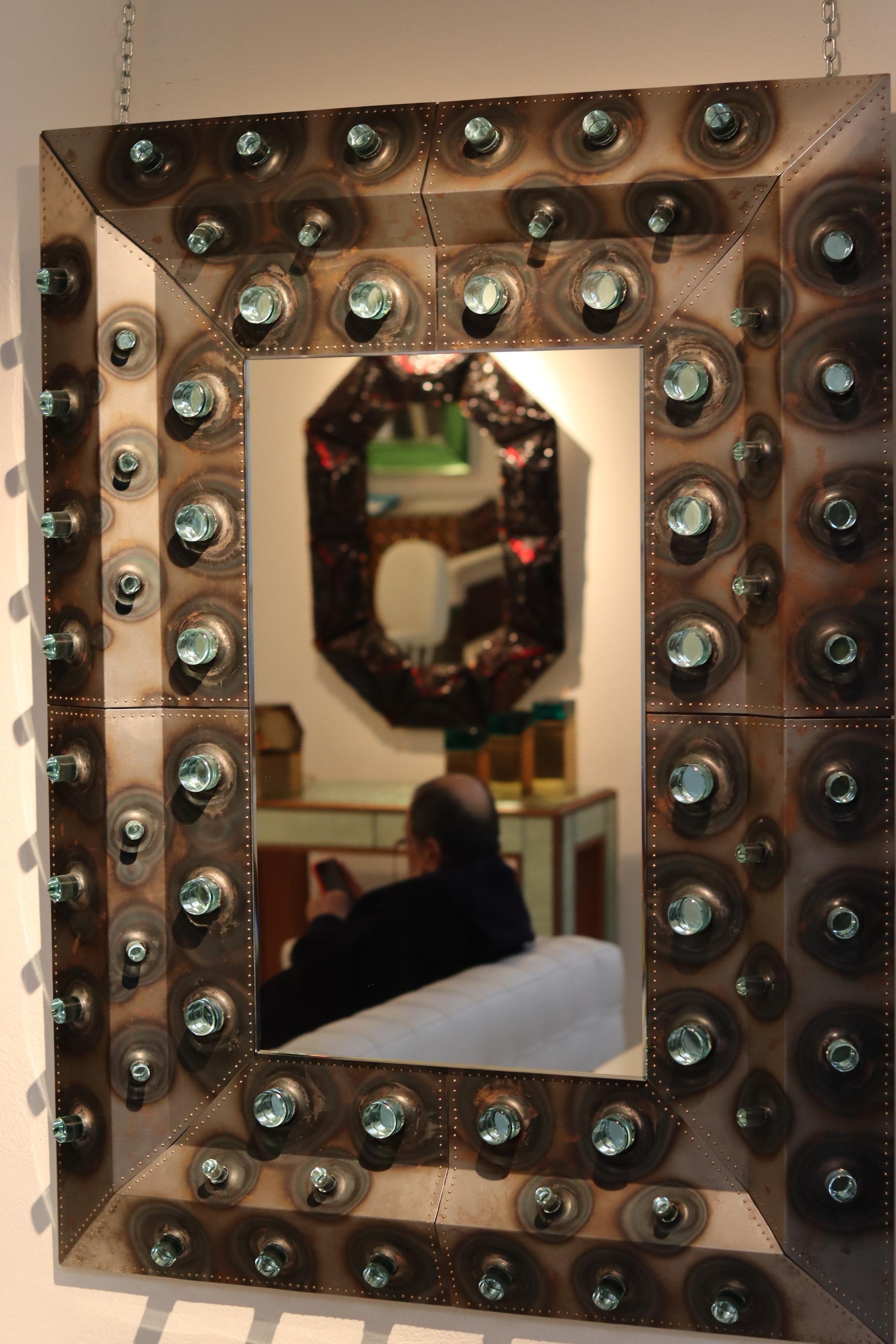 Spechio NEMO
exemple unique de grand miroir mural de style brutaliste, entièrement fabriqué à la main en Italie.
Cette œuvre brutaliste de Roberto Giulio Rida, réalisée en collaboration avec son fils Morgan, est sans aucun doute atypique d'un point