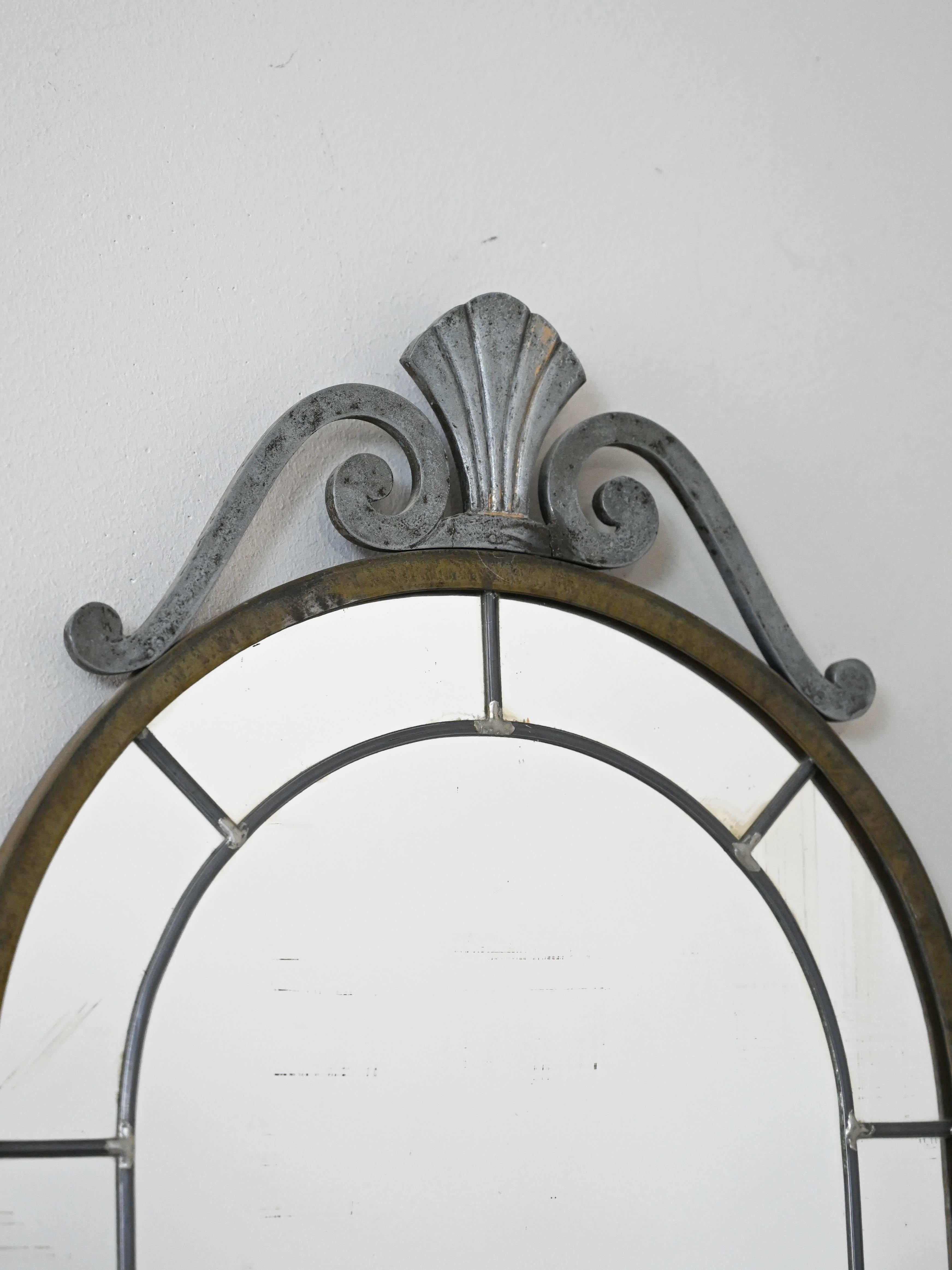 Specchio di produzione nordica degli anni '50, con cornice in metallo e dettagli decorativi. Uno specchio dalle linee classiche e intramontabili.

Specchio vintage realizzato negli anni '50, con cornice in metallo e dettagli decorativi nella parte
