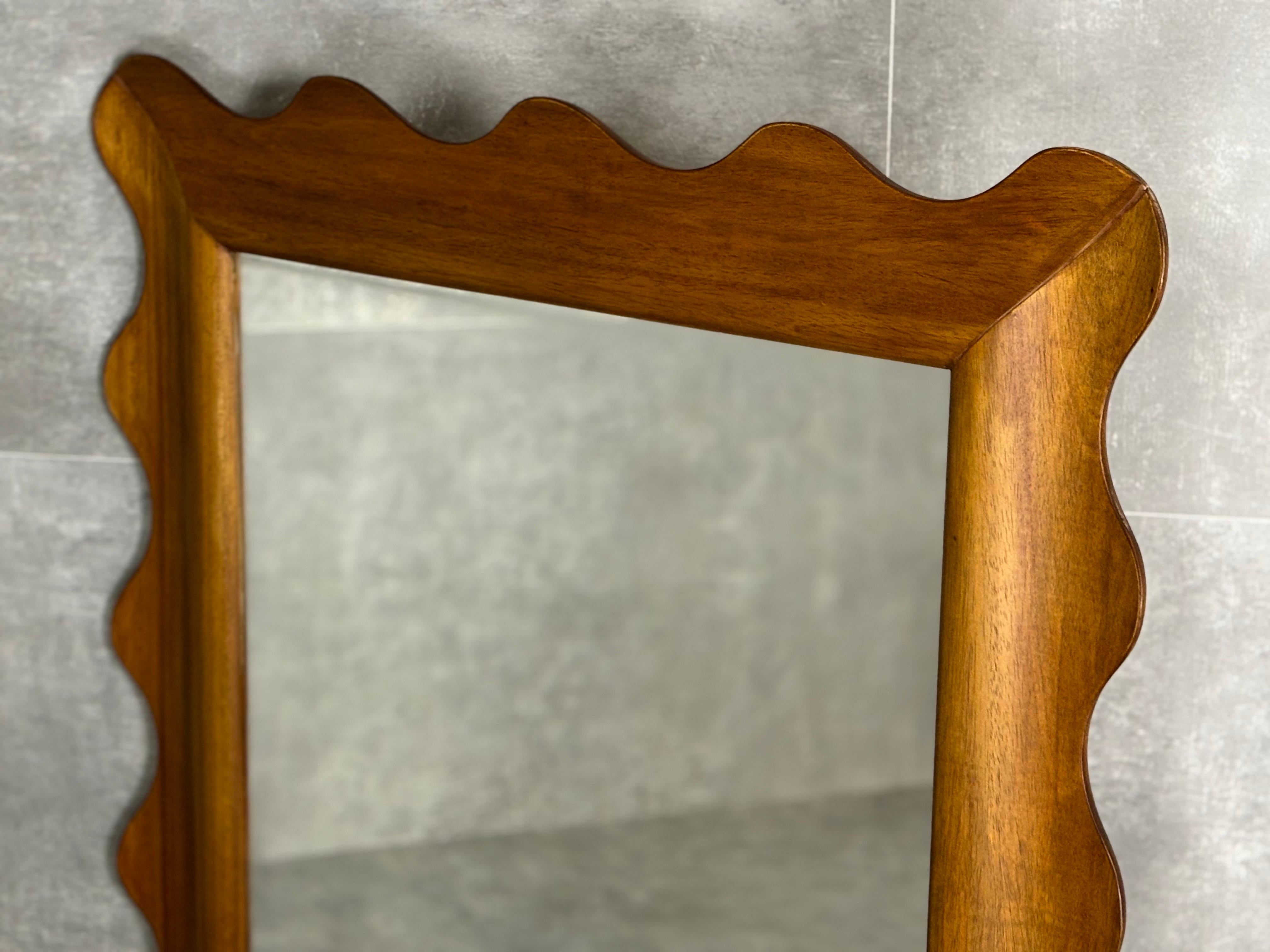 Specchio contemporaneo con cornice in legno ondulata.