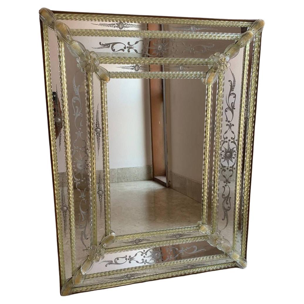 Goldspiegel der Gebrüder Barbini Veneziani, um 1960.
Die Verzierungen mit Muranoblumen und langen, gedrehten Glaslamellen an den Rändern des Spiegels erinnern an die Renaissancezeit.
