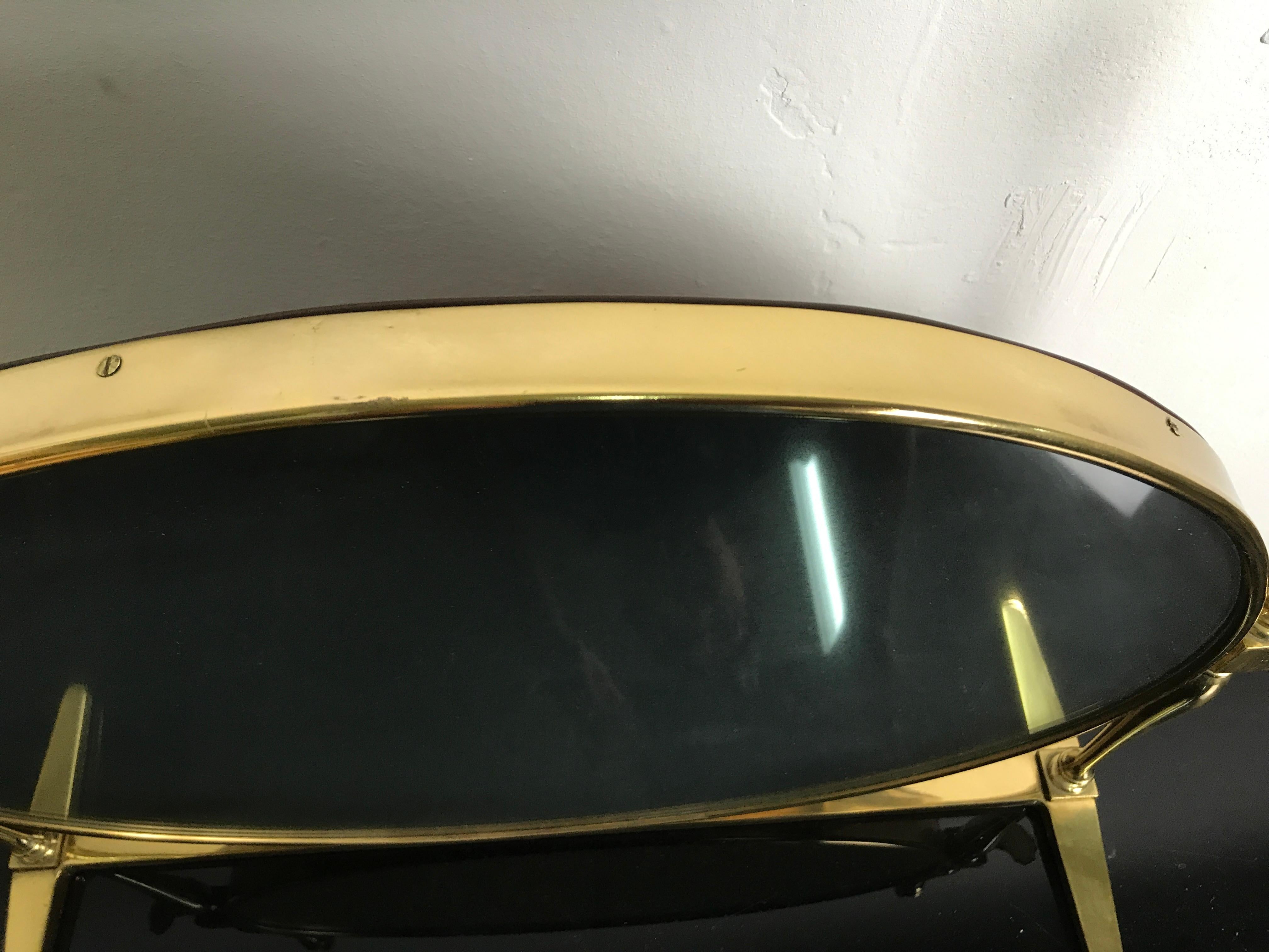 Specchio ovale regolabile in ottone anni 40-50 attribuibile al dedigner Paolo Buffa, le misure sono larghezza base cm55 larghezza max cm65 larghezza specchio cm50, altezza max cm50 altezza specchio cm40. Lo specchio è patinato, in quanto leggermente
